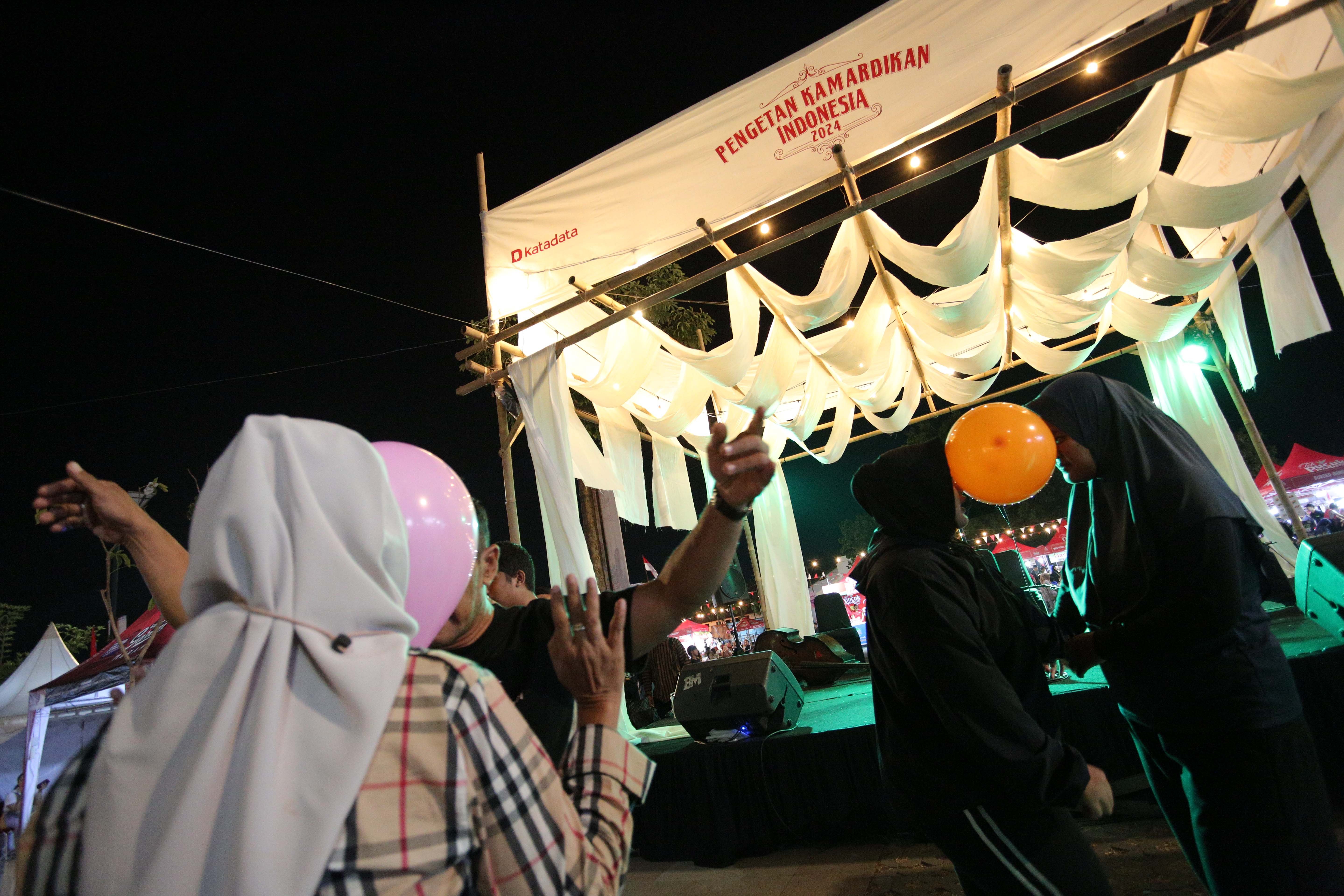 Sejumlah pengunjung mengikuti lomba joget balon berpasangan yang diadakan saat Festival Kuliner Dua Generasi di Pamedan Pura Mangkunegaran, Solo, Jawa Tengah, Sabtu (17/8/2024). Festival kuliner yang merupakan salah satu rangkaian acara pada 