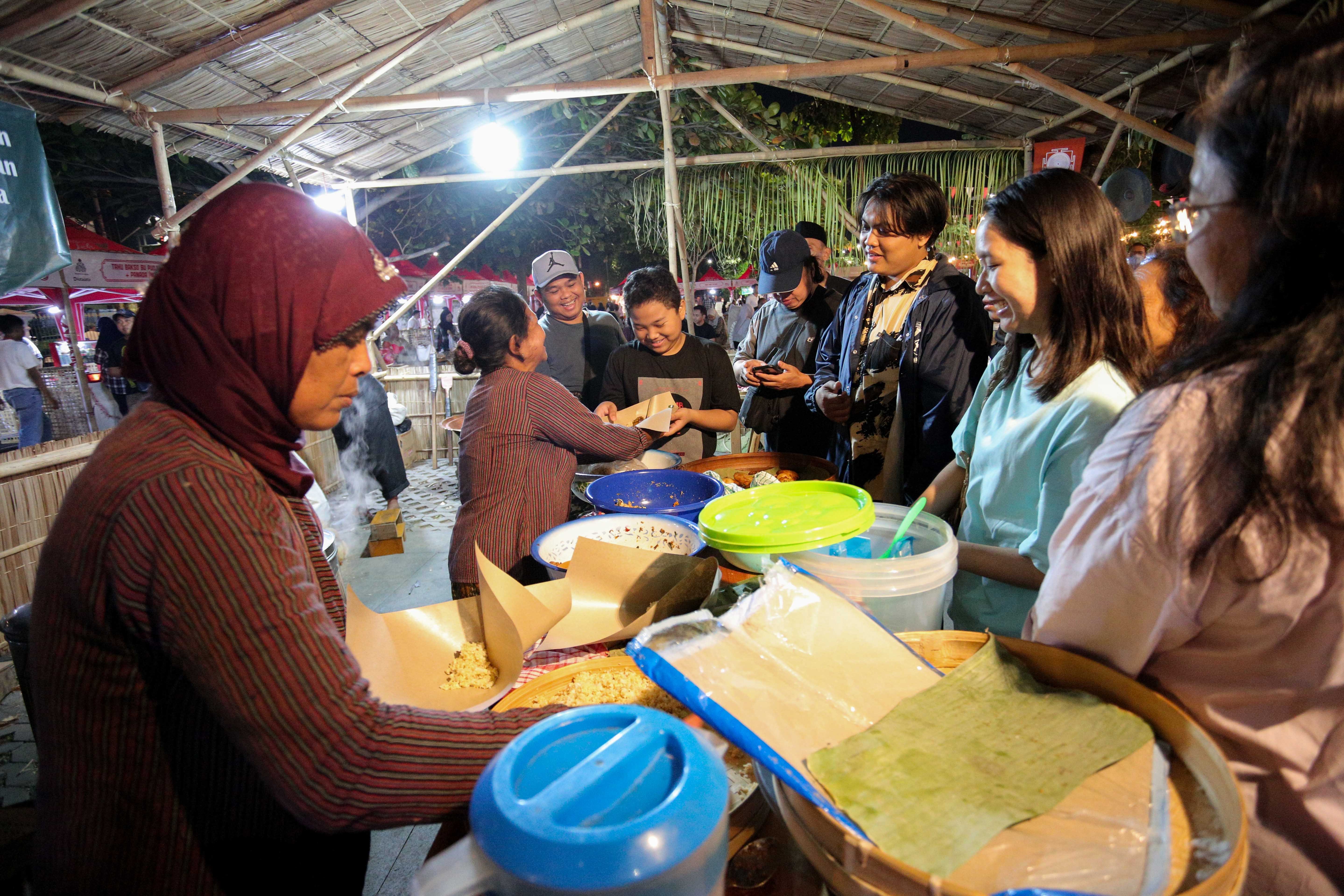 Pengunjung memesan makanan yang disajikan di stan Gubuk Gandhok saat Festival Kuliner Dua Generasi di Pamedan Pura Mangkunegaran, Solo, Jawa Tengah, Sabtu (17/8/2024). Festival kuliner yang merupakan salah satu rangkaian acara pada 