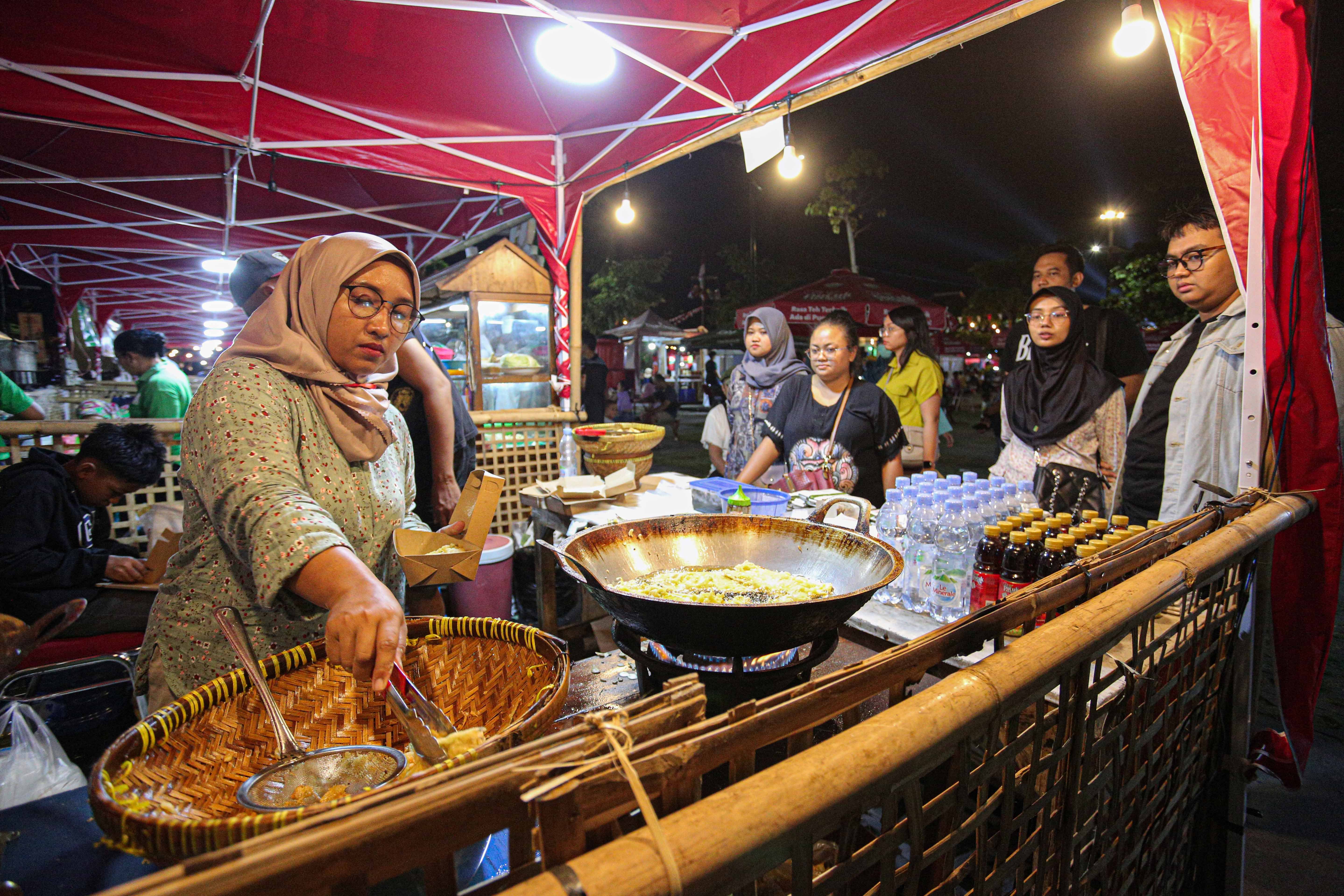 Pengunjung memesan makanan yang dijual di stan Mendoan dan Tahu Petis Banyumas saat Festival Kuliner Dua Generasi di Pamedan Pura Mangkunegaran, Solo, Jawa Tengah, Sabtu (17/8/2024). Festival kuliner yang merupakan salah satu rangkaian acara pada 