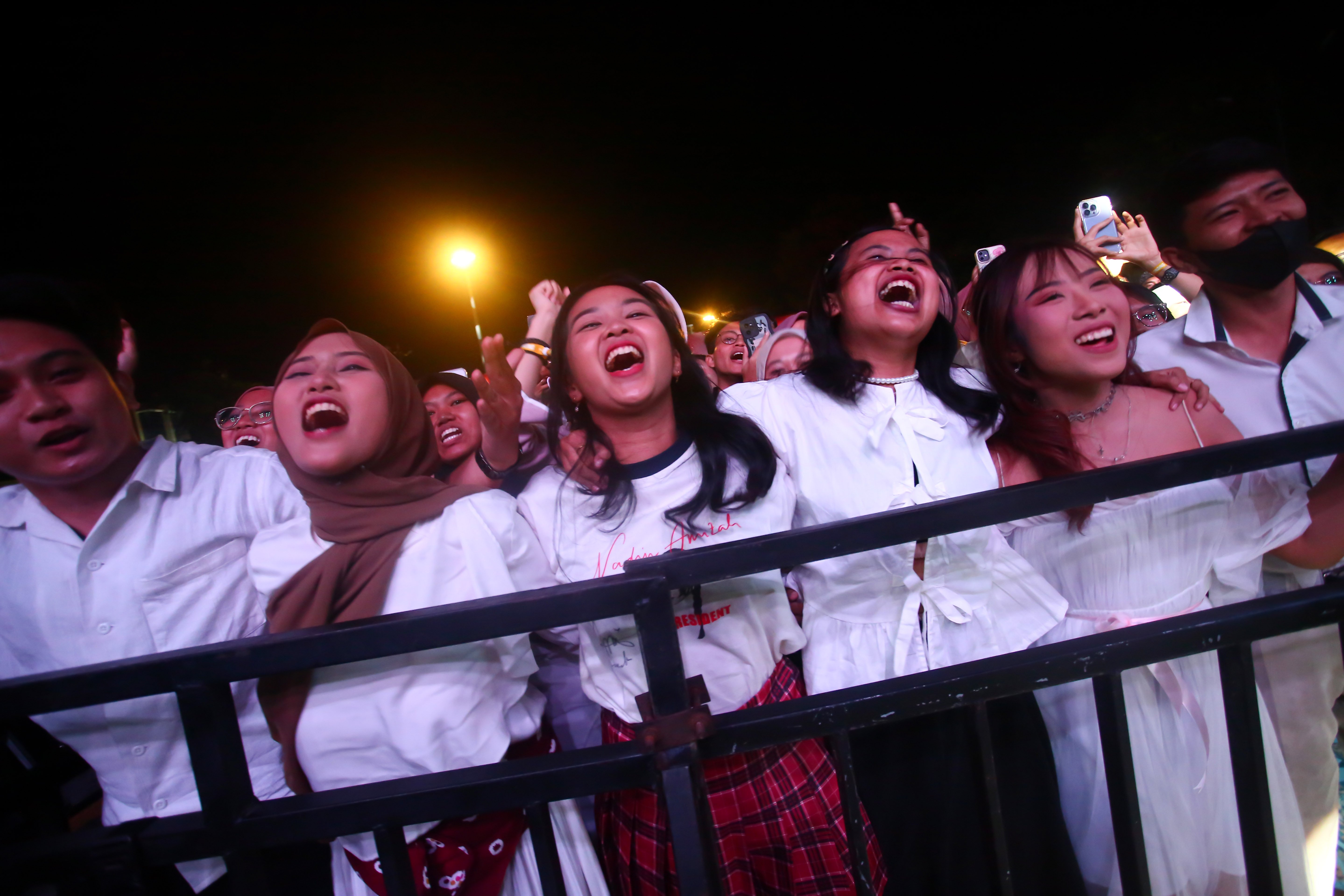 Sejumlah penonton bernyanyi bersama saat Nadin Amizah tampil dalam Konser Dua Generasi di Pamedan Pura Mangkunegaran, Solo, Jawa Tengah, Minggu (18/8/2024). Konser musik yang merupakan salah satu rangkaian acara Pengetan Kamardikan Indonesia ini digelar dalam rangka memeriahkan Hari Ulang Tahun (HUT) Kemerdekaan Indonesia ke-79 yang menampilkan dua musisi lintas generasi yaitu Iwan Fals dan Nadin Amizah.