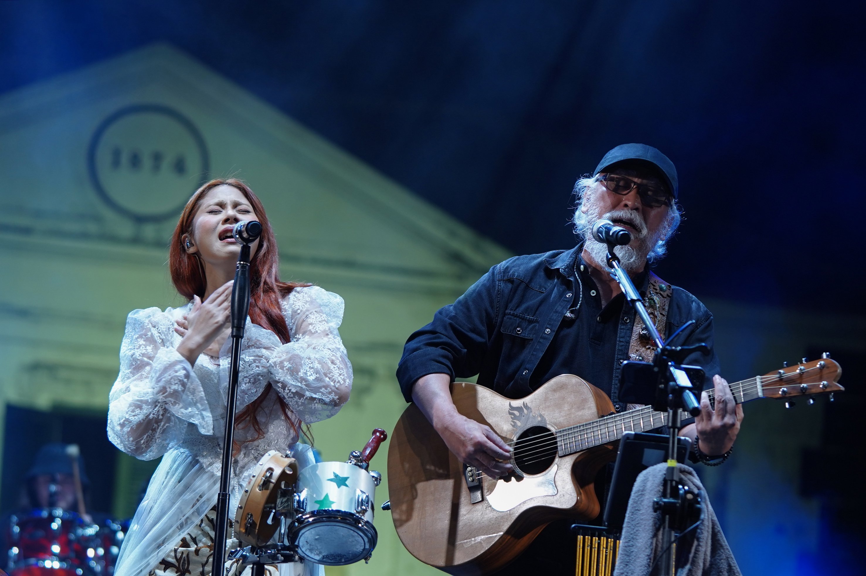 Penyanyi Iwan Fals (kanan) berkolaborasi dengan Nadin Amizah (kiri) saat tampil dalam Konser Dua Generasi di Pamedan Pura Mangkunegaran, Solo, Jawa Tengah, Minggu (18/8/2024). Konser musik yang merupakan salah satu rangkaian acara Pengetan Kamardikan Indonesia ini digelar dalam rangka memeriahkan Hari Ulang Tahun (HUT) Kemerdekaan Indonesia ke-79 yang menampilkan dua musisi lintas generasi yaitu Iwan Fals dan Nadin Amizah.