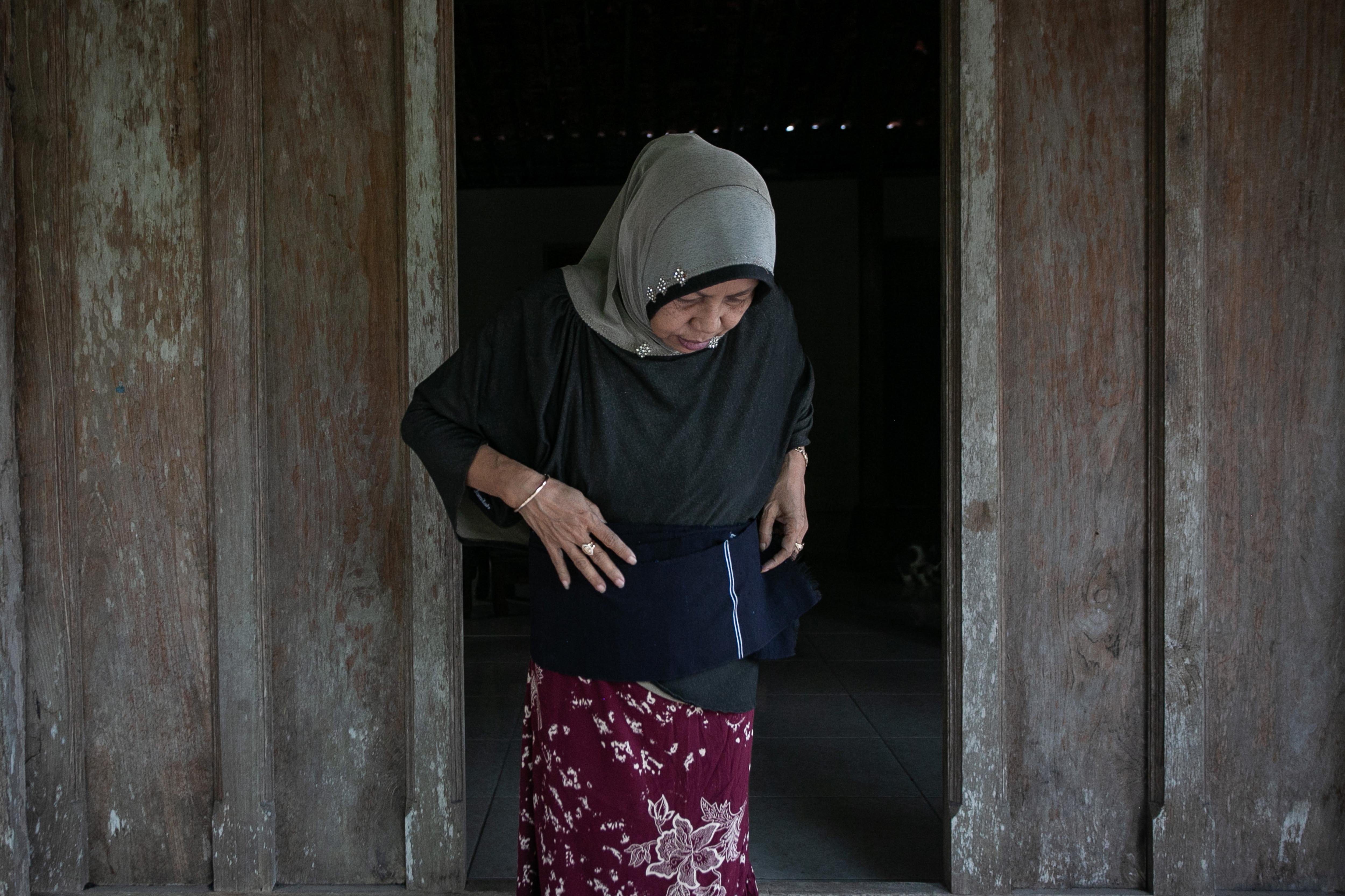 Seorang wanita mencoba mengenakan kain tenun setagen produksi penenun di Desa Luwang, Gatak, Sukoharjo, Jawa Tengah.