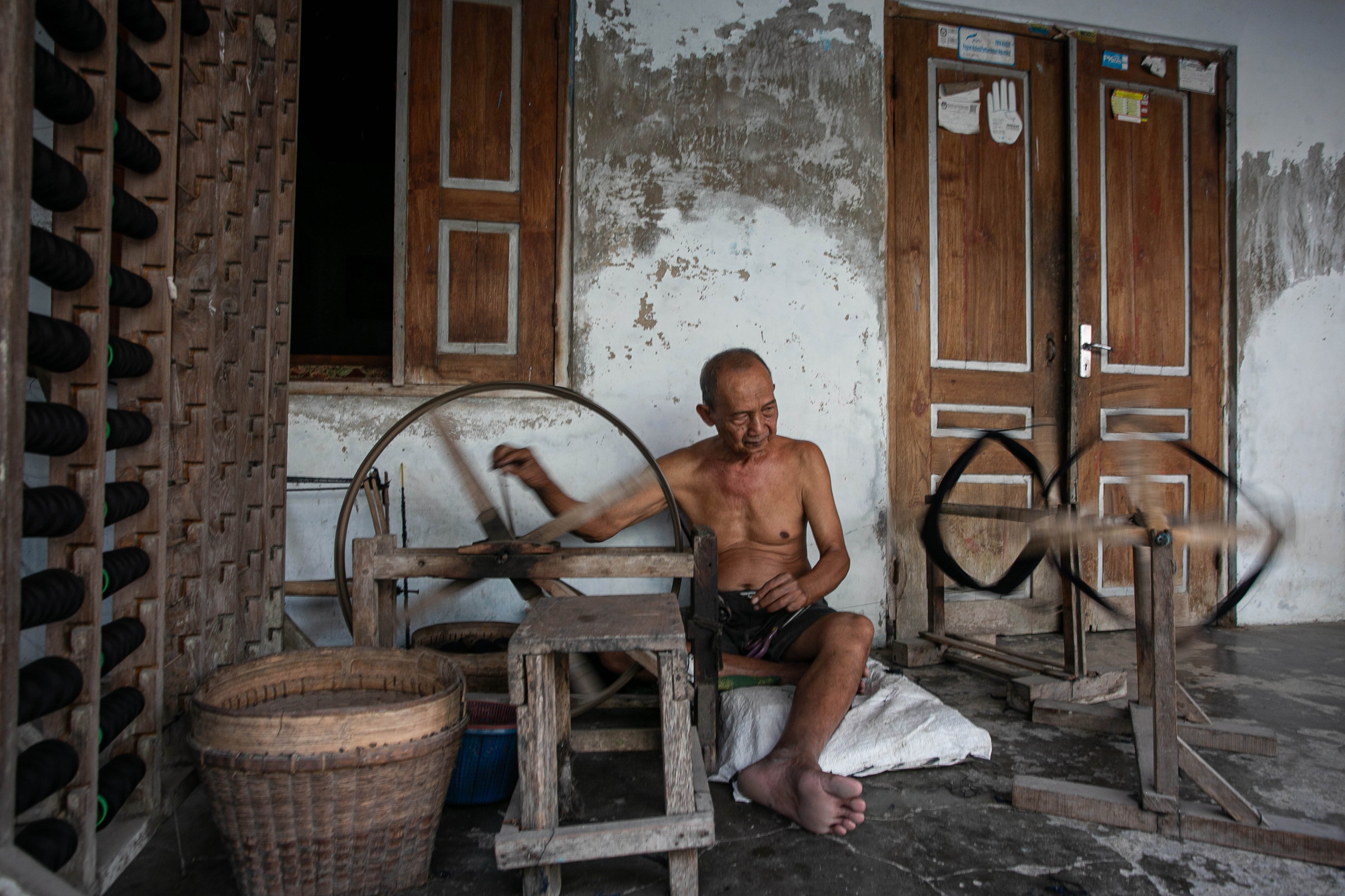 Penenun tradisional Mbah Marimin memintal benang dengan alat tradisional saat menyelesaikan pembuatan kain tenun setagen di kawasan Sentra Industri Setagen, Desa Luwang, Gatak, Sukoharjo, Jawa Tengah.