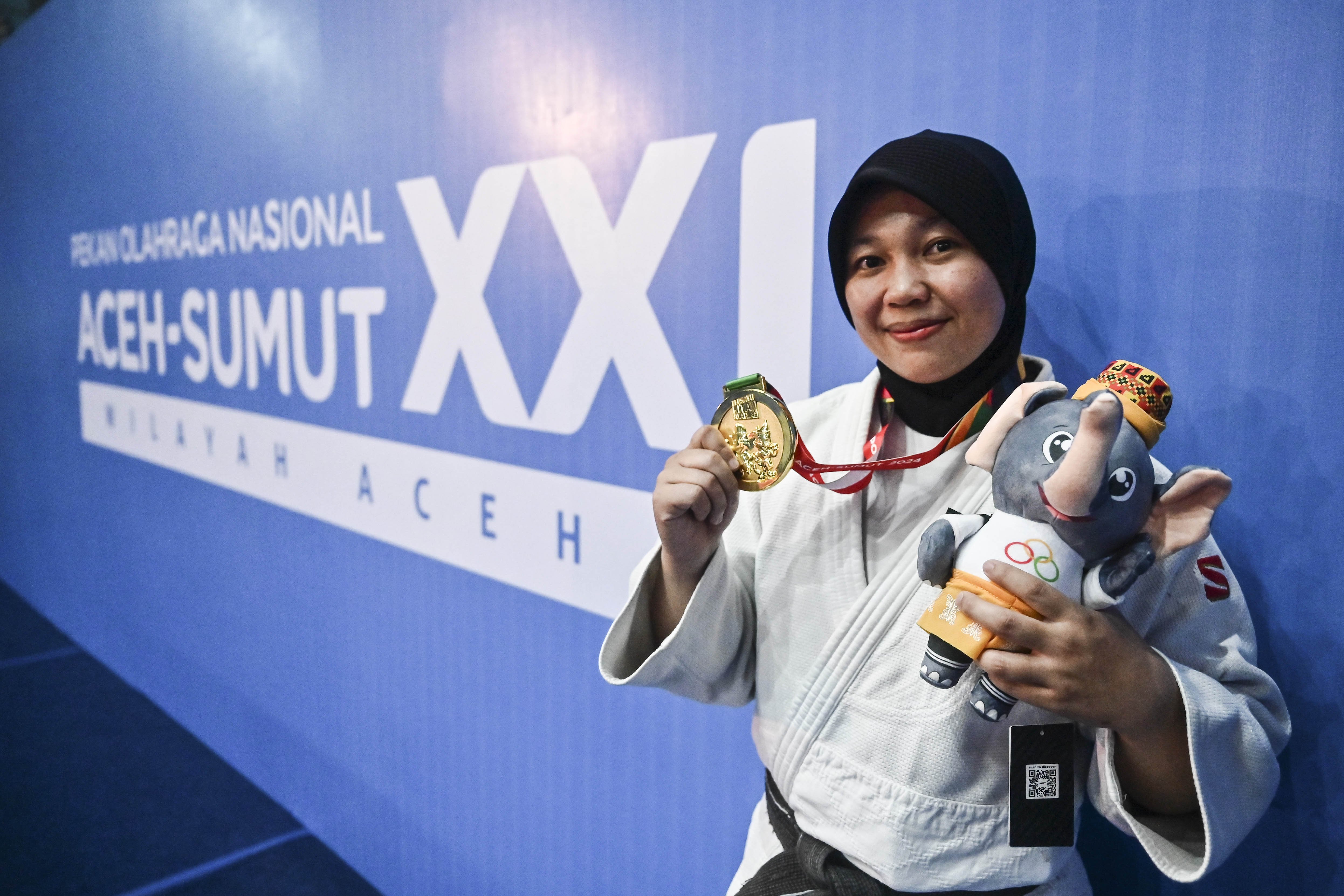 Judoka Jawa Timur Hevrilia Windawati berpose menujukkan medali emasnya usai menang melawan judoka DKI Jakarta Tika Syafitri (kanan) dalam babak final nomor -70 kg putri PON XXI Aceh-Sumut 2024 di GOR Universitas Syiah Kuala, Banda Aceh, Aceh, Rabu (11/9/2024). Hevrilia Windawati menang dalam pertandingan tersebut dan berhasil meraih medali emas, sementara medali perak diraih Tika Syafitri, serta medali perunggu diraih judoka Jawa Barat Siti Latipah dan judoka Sumatera Utara Nanda Olivia Banurea.