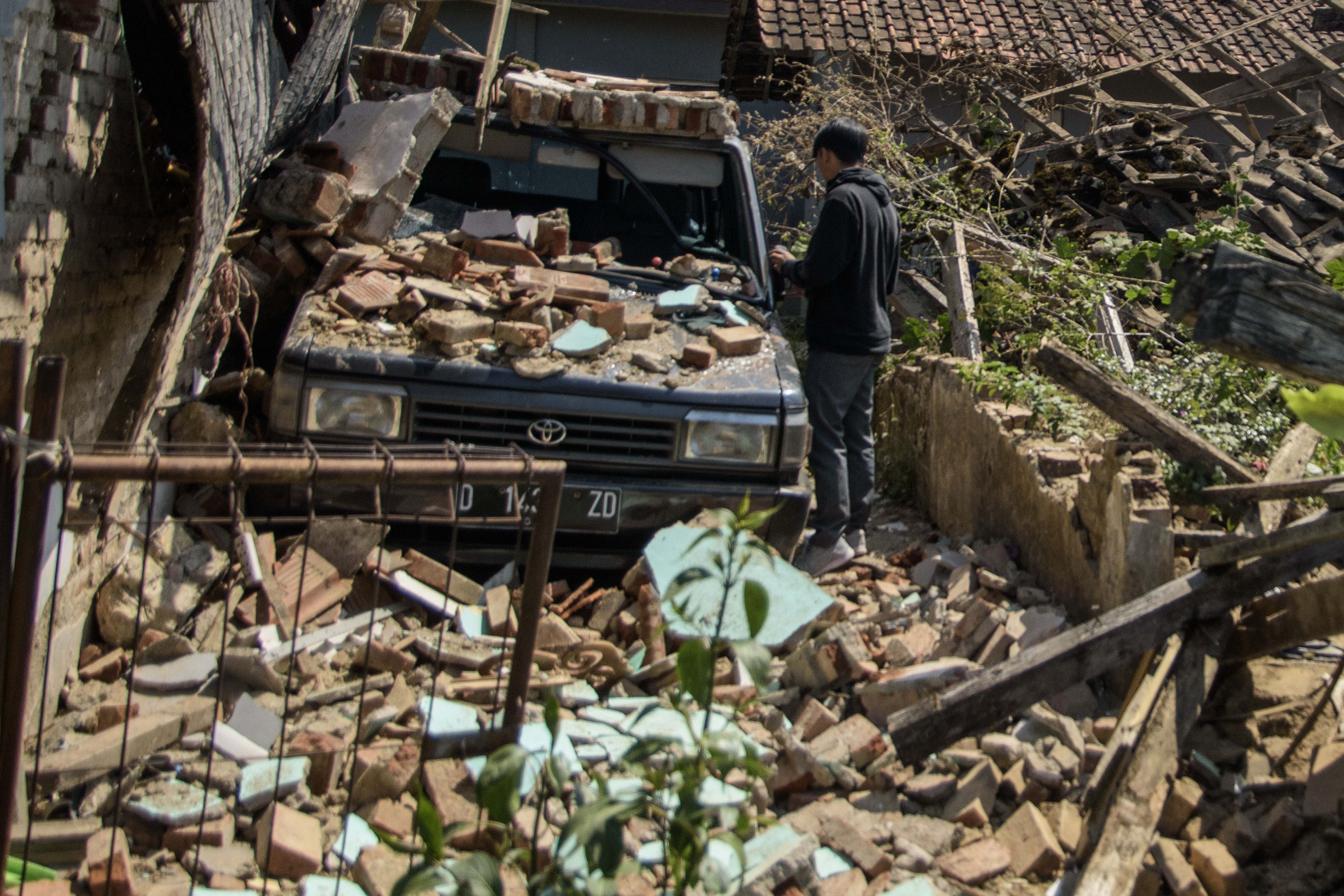 Warga membersihkan puing rumah yang runtuh pascagempa bumi di Desa Cibeureum, Kertasari, Kabupaten Bandung, Jawa Barat, Rabu (18/9/2024). Menurut data sementara BPBD Provinsi Jawa Barat, gempa berkekuatan 5.0 Magnitudo tersebut mengakibatkan 8 unit rumah, 2 fasilitas kesehatan, 1 sarana pendidikan, dan 1 tempat ibadah mengalami kerusakan.