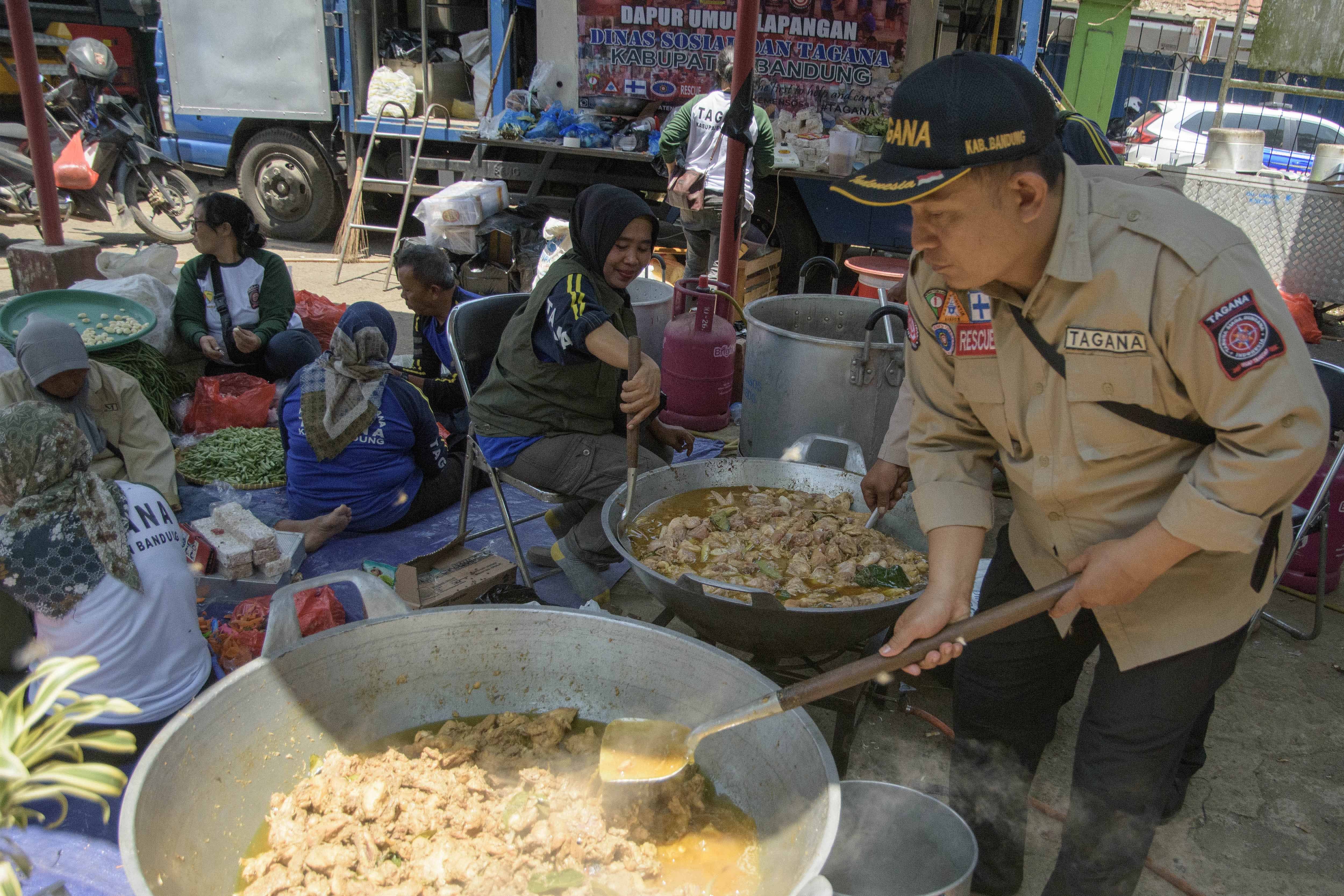 Sejumlah petugas Tagana Kabupaten Bandung menyiapkan makanan di posko dapur umum lokasi terdampak gempa bumi di Kertasari, Kabupaten Bandung, Jawa Barat, Kamis (19/9/2024). Pemerintah Kabupaten (Pemkab) Bandung mendirikan dapur umum di Kecamatan Kertasari untuk melayani sekitar 2.000 pengungsi dari delapan desa di Kecamatan Kertasari yang terdampak gempa bumi agar dapat terpenuhi kebutuhan pangannya di masa tanggap darurat. 