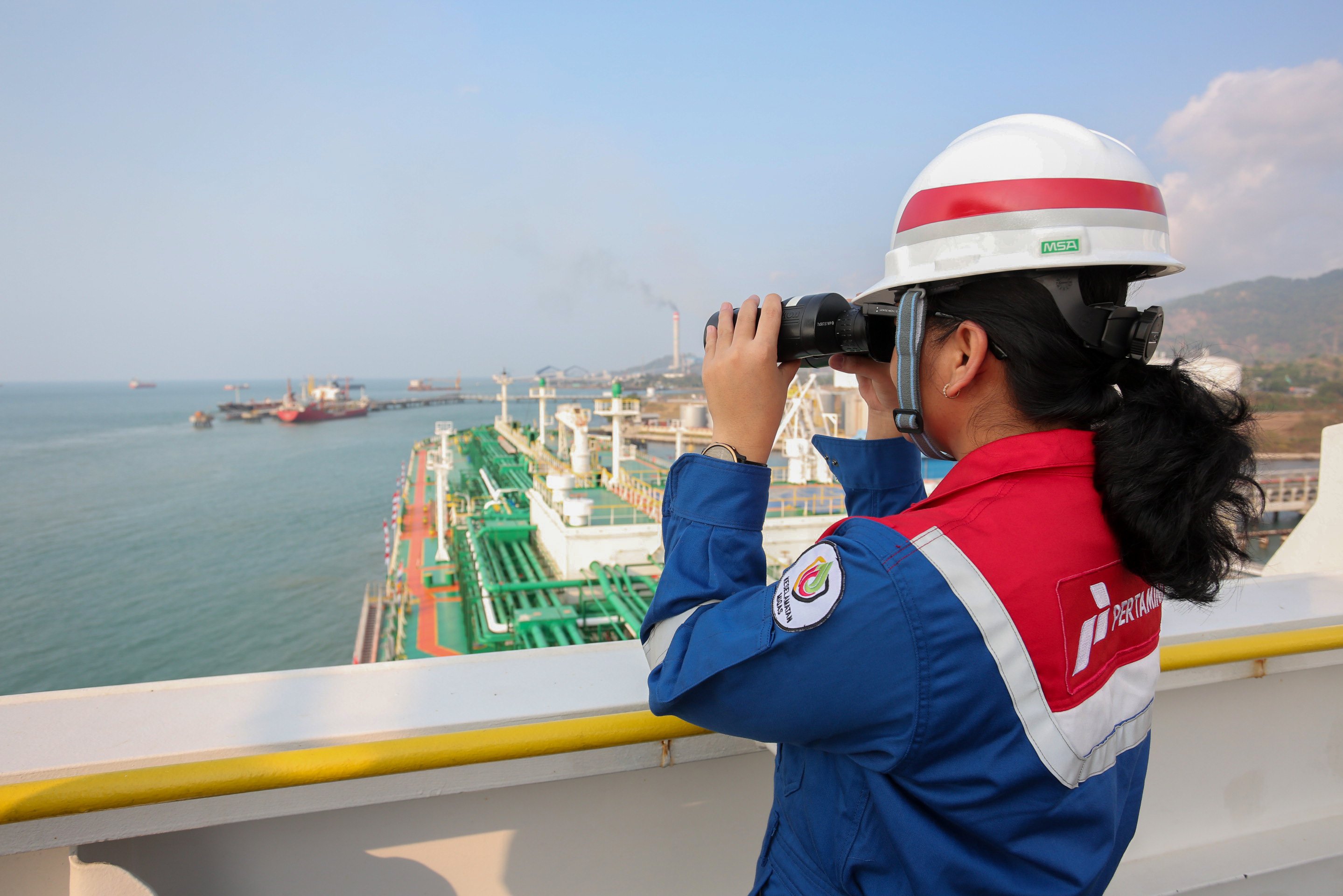Awak kapal memantau situasi sekitar menggunakan teropong di anjungan kapal Pertamina Gas 1 yang sedang berlabuh di Terminal LPG Tanjung Sekong, Kota Cilegon, Banten.