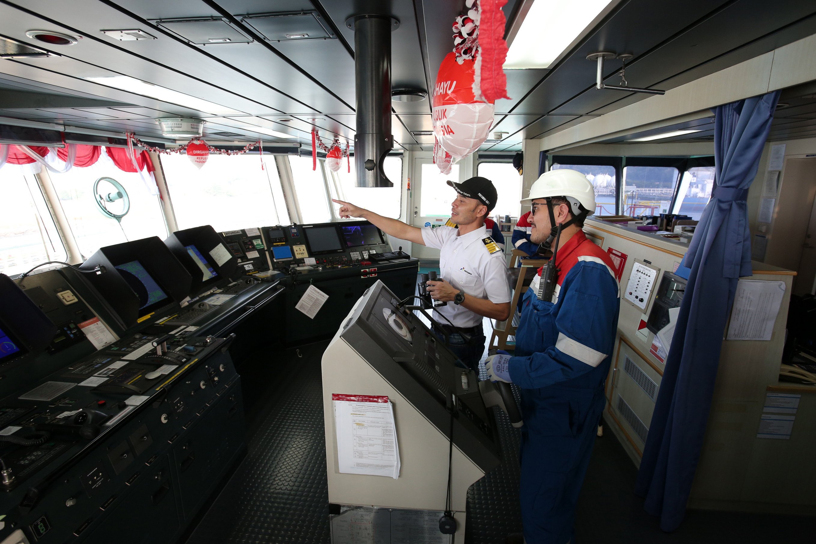 Kapten Prawoto (kiri) bersama awak kapal memantau situasi sekitar di anjungan kapal Pertamina Gas 1 yang sedang berlabuh di Terminal LPG Tanjung Sekong, Kota Cilegon, Banten. 