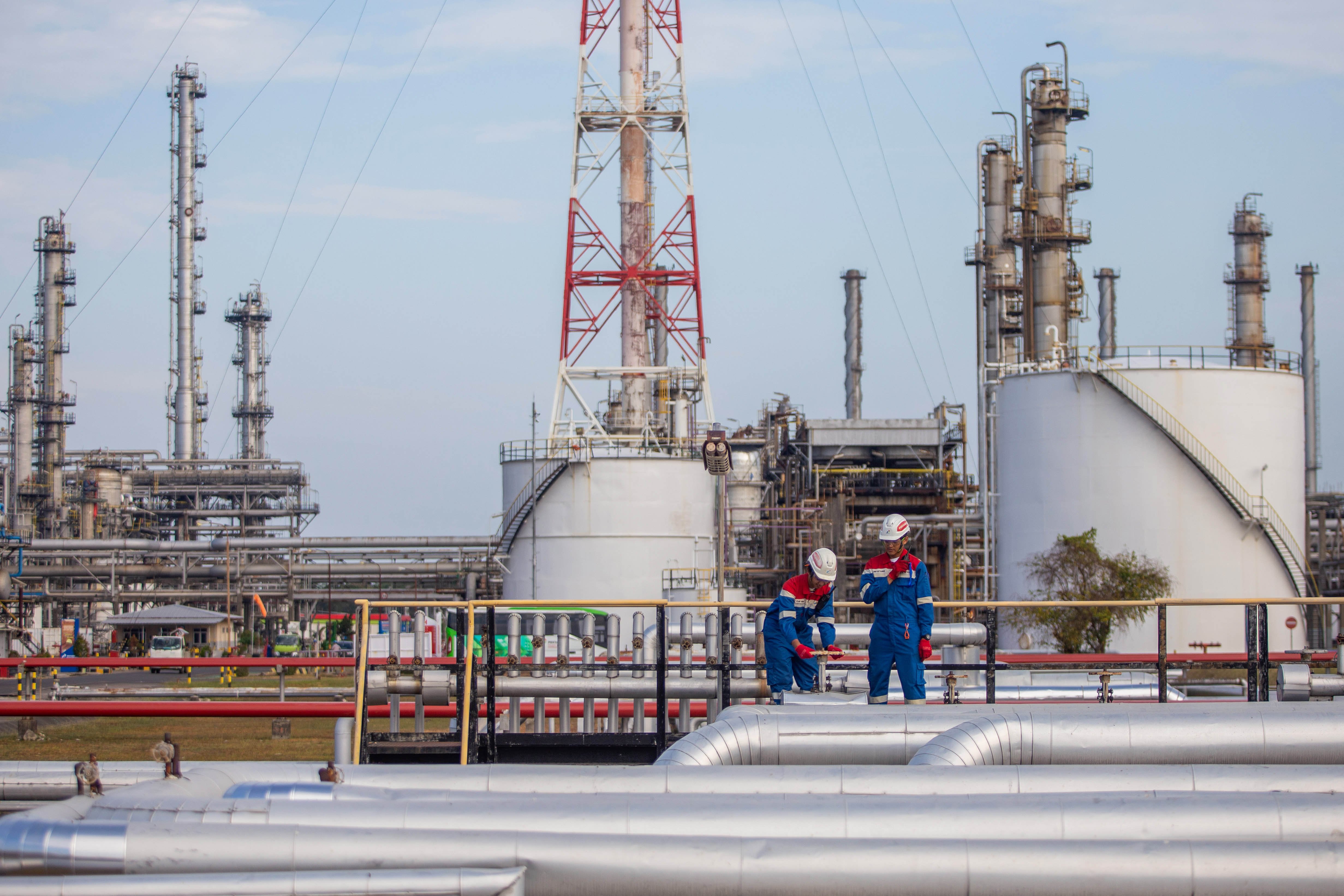 Dua petugas Pertamina memeriksa pipa jalur distribusi BBM yang akan dikirim ke terminal bahan bakar untuk kebutuhan Jakarta, banten dan Jawa barat di Kilang Pertamina Internasional (KPI) Unit Balongan di Indramayu, Jawa Barat.