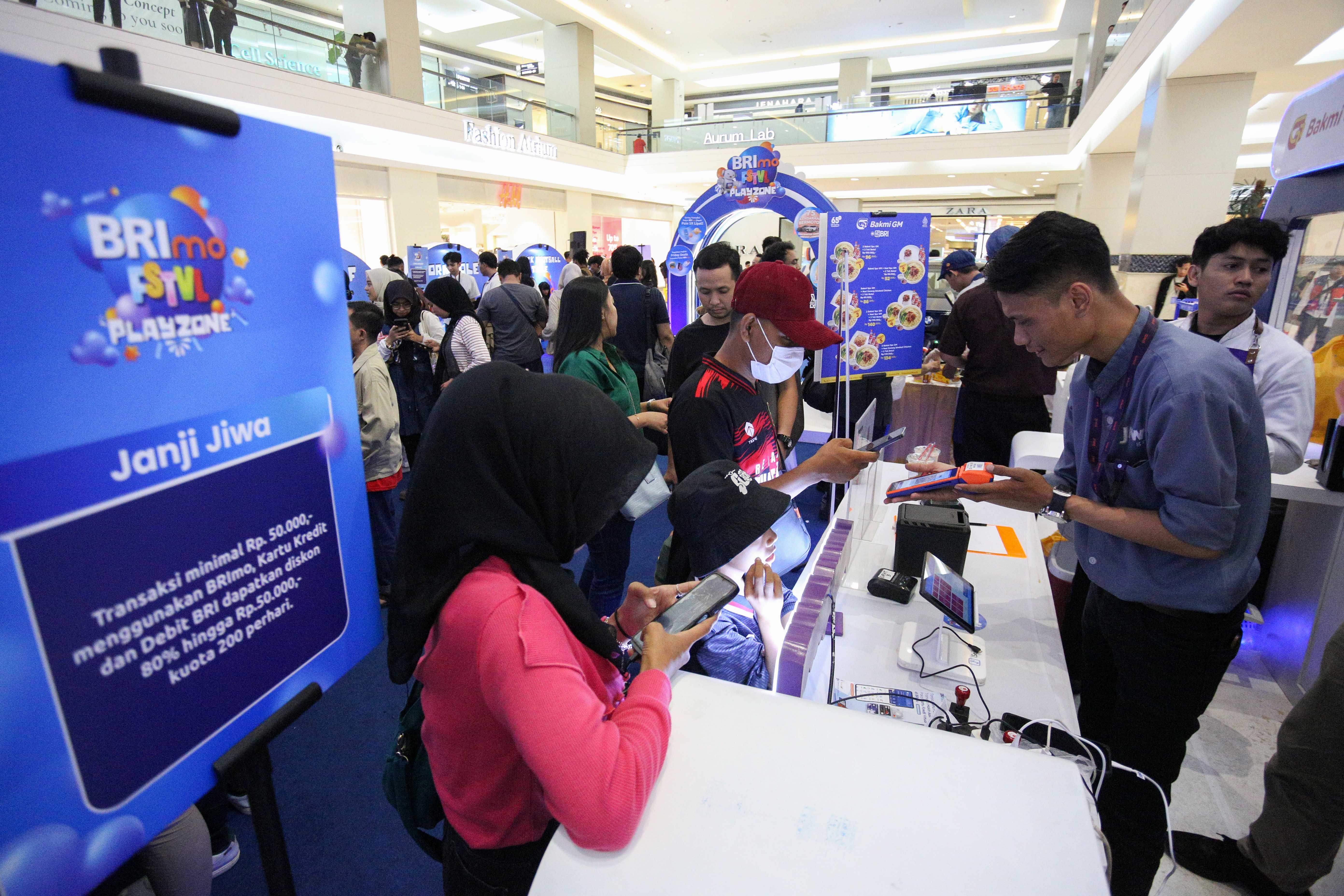 Pengunjung bertansaksi menggunakan aplikasi mobile banking BRImo saat membeli minuman di salah satu stan pada acara BRImo FSTVL Playzone di Fashion Atrium, Mall Kota Kasablanka, Jakarta, Sabtu (12/10/2024). Dalam rangka memperkenalkan fitur terbaru dari super apps BRImo, PT Bank Rakyat Indonesia (Persero) Tbk menggelar BRImo FSTVL Playzone dengan berbagai kegiatan menarik mulai dari talk show, games corner hingga penampilan musik dari penyanyi Fabio Asher.