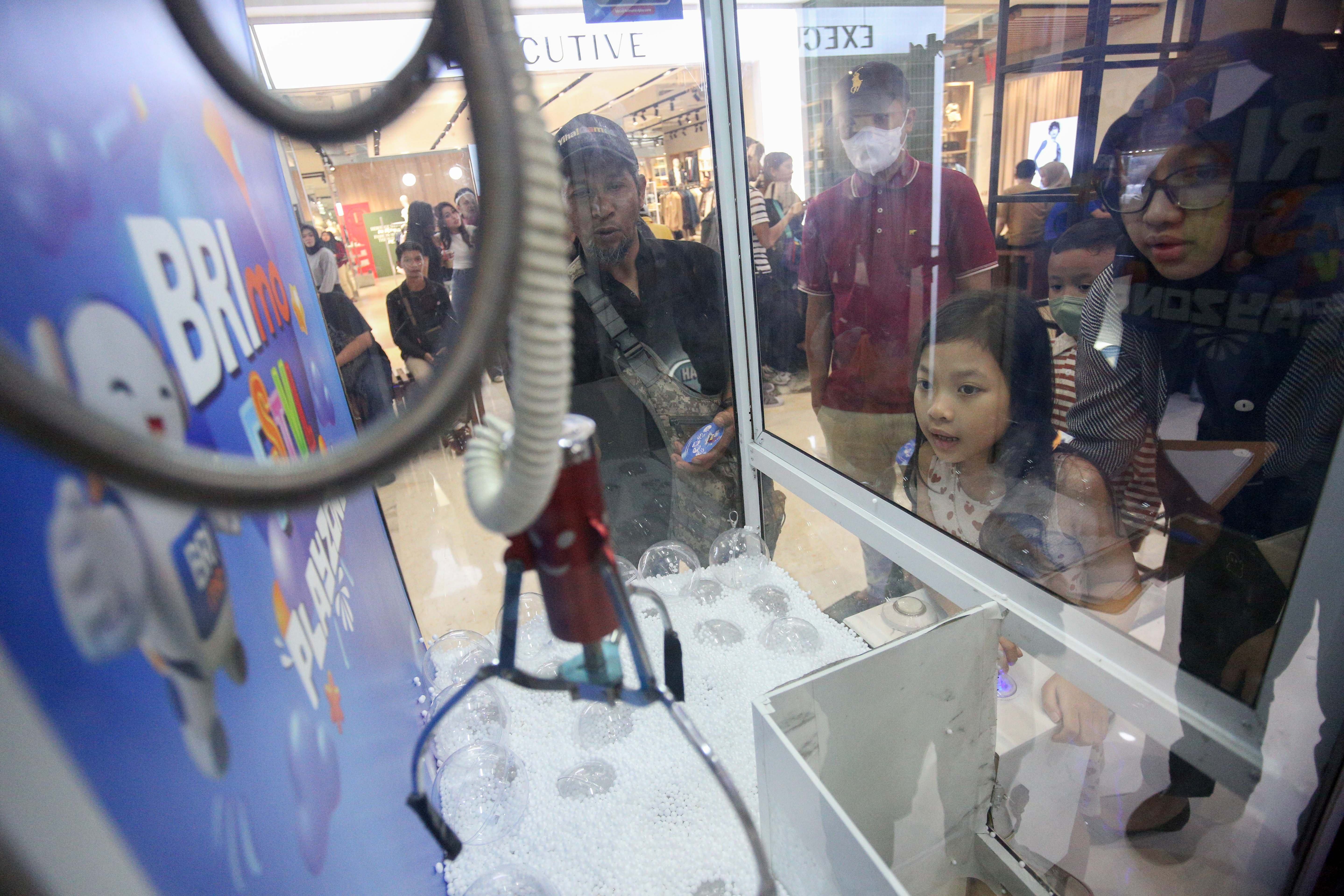 Pengunjung mencoba permainan claw machine saat acara BRImo FSTVL Playzone di Fashion Atrium, Mall Kota Kasablanka, Jakarta, Sabtu (12/10/2024). Dalam rangka memperkenalkan fitur terbaru dari super apps BRImo, PT Bank Rakyat Indonesia (Persero) Tbk menggelar BRImo FSTVL Playzone dengan berbagai kegiatan menarik mulai dari talk show, games corner hingga penampilan musik dari penyanyi Fabio Asher.