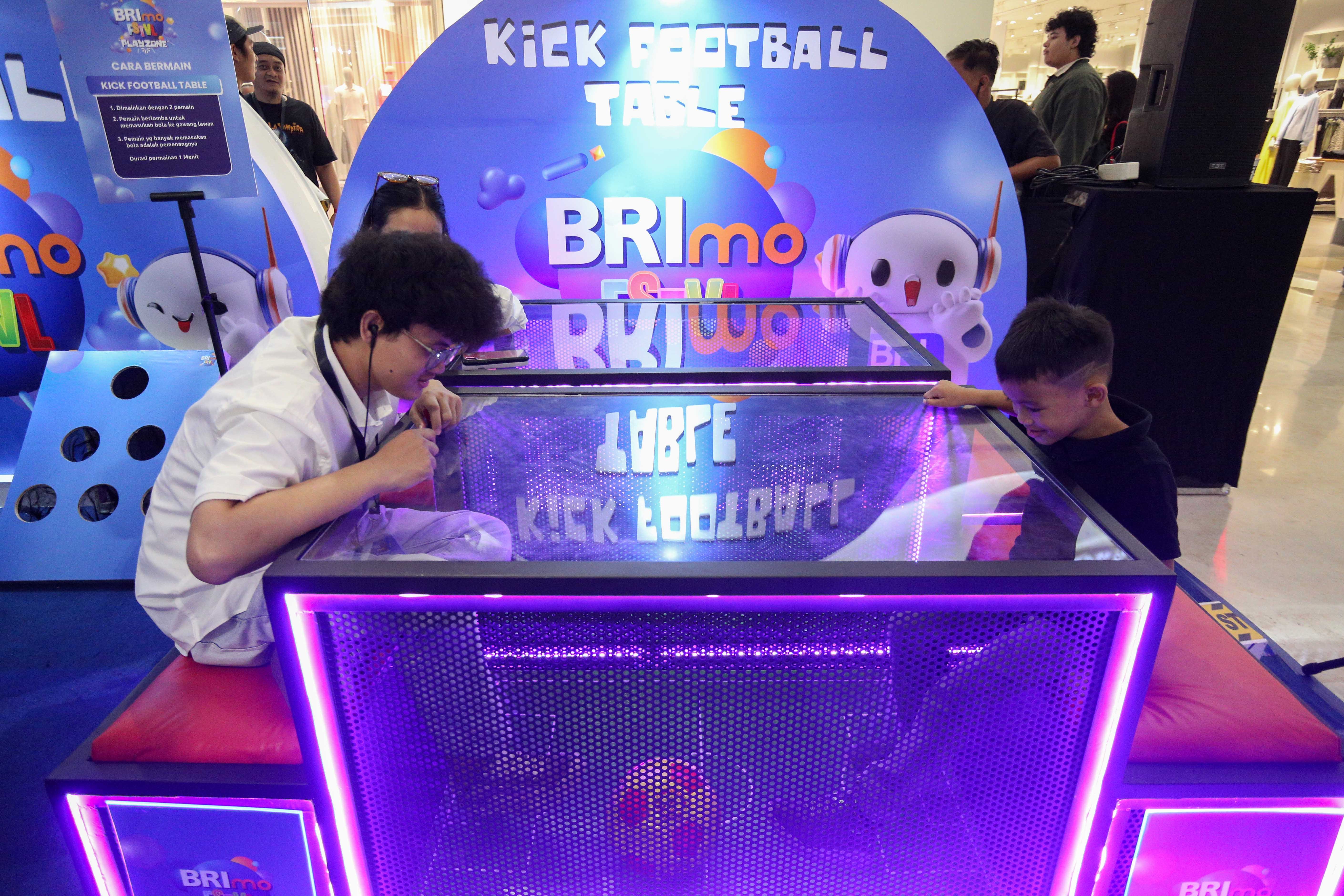 Pengunjung mencoba permainan kick football table saat acara BRImo FSTVL Playzone di Fashion Atrium, Mall Kota Kasablanka, Jakarta, Sabtu (12/10/2024). Dalam rangka memperkenalkan fitur terbaru dari super apps BRImo, PT Bank Rakyat Indonesia (Persero) Tbk menggelar BRImo FSTVL Playzone dengan berbagai kegiatan menarik mulai dari talk show, games corner hingga penampilan musik dari penyanyi Fabio Asher.