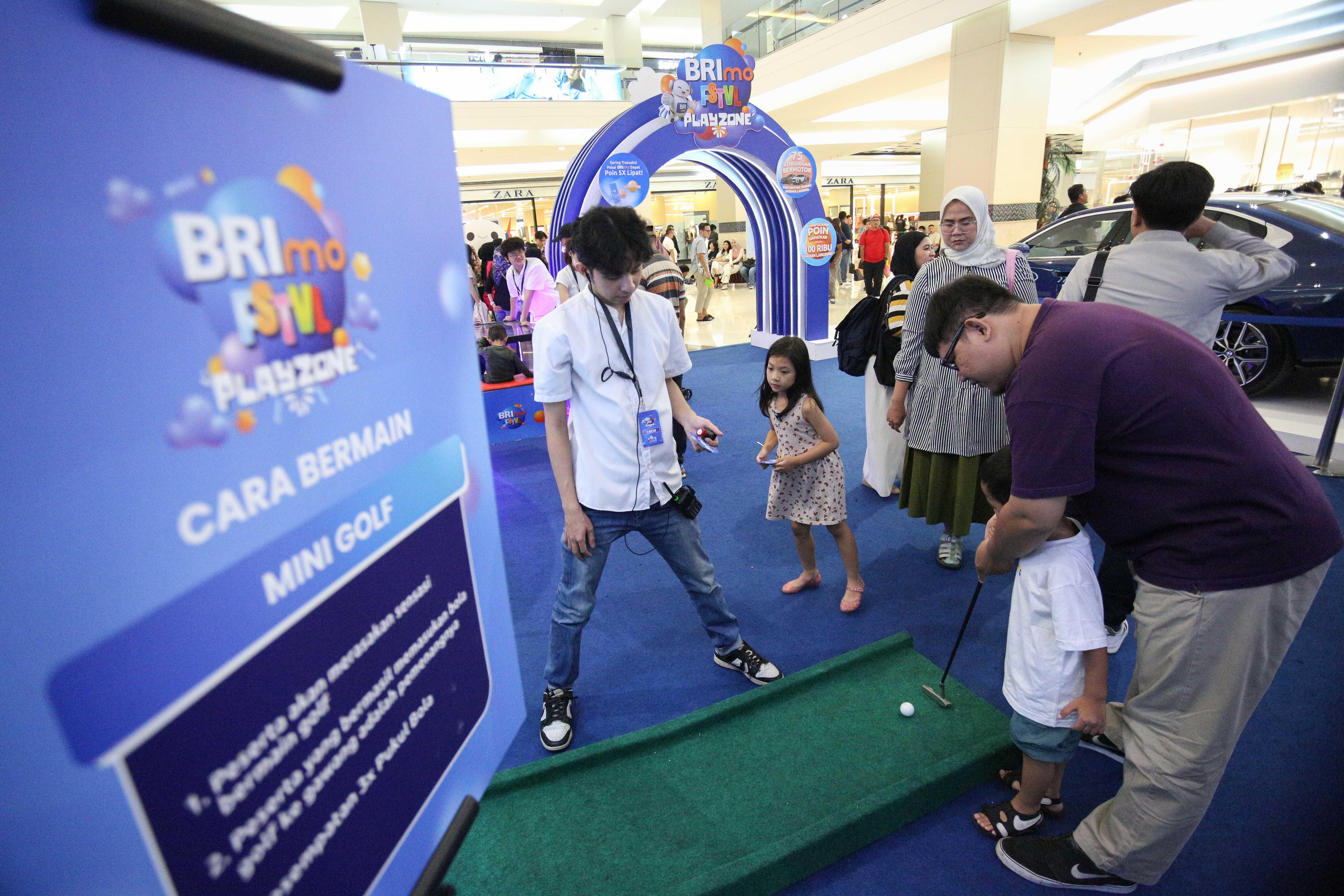 Pengunjung mencoba permainan mini golf saat acara BRImo FSTVL Playzone di Fashion Atrium, Mall Kota Kasablanka, Jakarta, Sabtu (12/10/2024). Dalam rangka memperkenalkan fitur terbaru dari super apps BRImo, PT Bank Rakyat Indonesia (Persero) Tbk menggelar BRImo FSTVL Playzone dengan berbagai kegiatan menarik mulai dari talk show, games corner hingga penampilan musik dari penyanyi Fabio Asher.