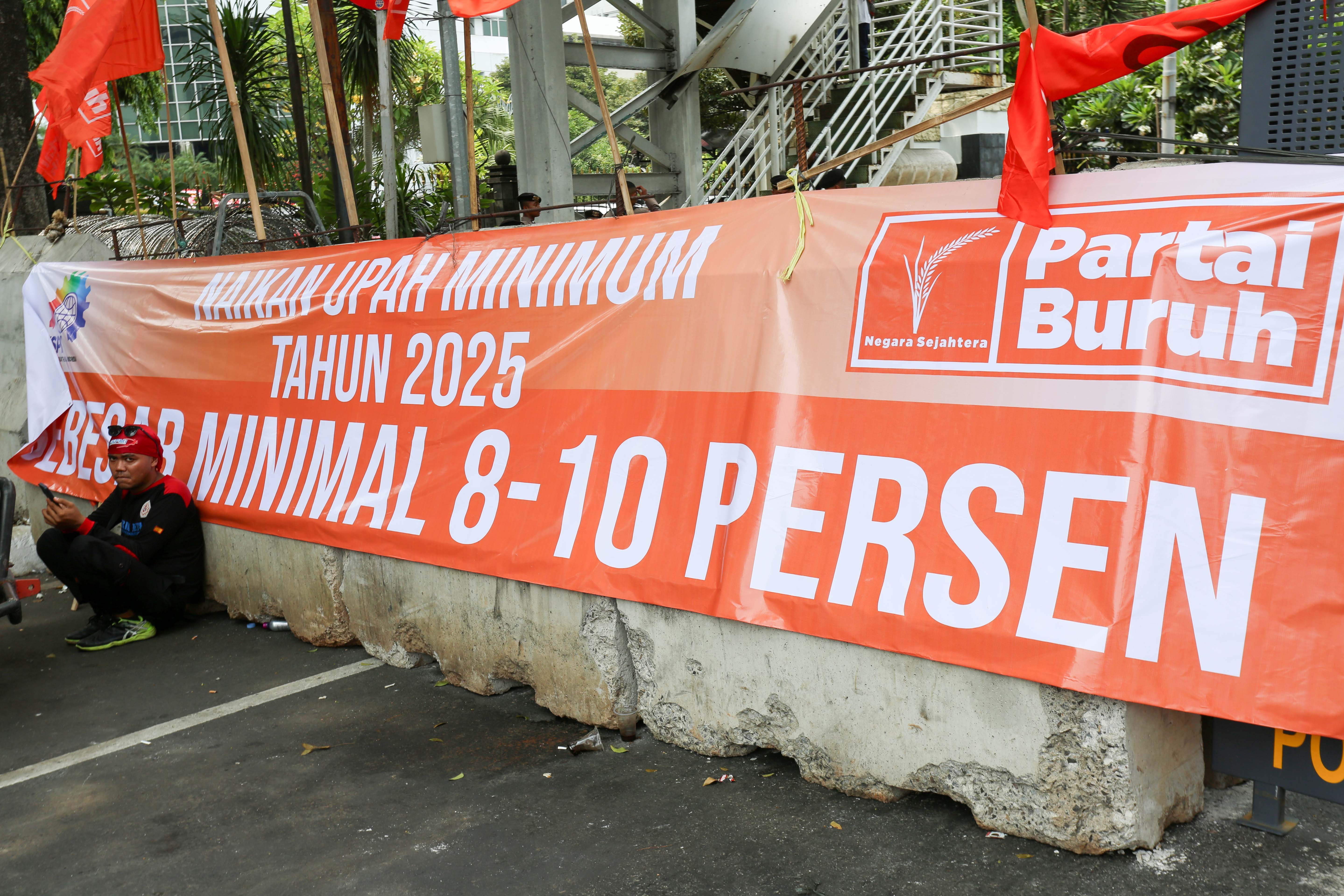Seorang buruh beristirahat saat mengikuti aksi unjuk rasa di kawasan Patung Kuda, Jakarta, Kamis (24/10/2024). Dalam aksinya tersebut buruh menuntut kepada pemerintah untuk menaikkan upah minimum tahun 2025 sebesar 8 hingga 10 persen.