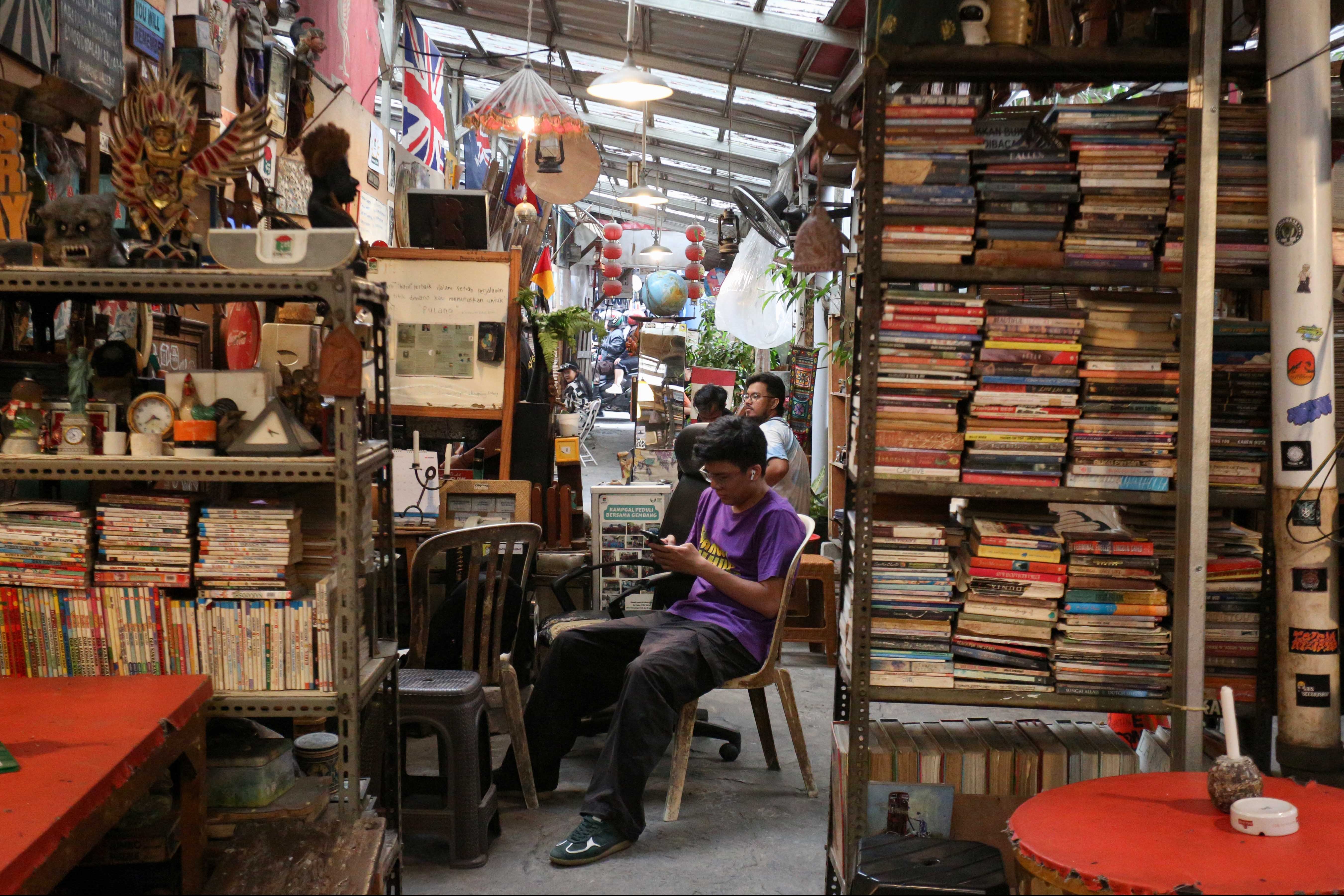 Pengunjung bersantai saat berkunjung ke Kampoeng Gallery di Kebayoran Lama, Jakarta Selatan, Rabu (16/10/2024). Dengan dihiasi oleh barang antik seperti radio, piringan hitam, majalah hingga ukiran kayu, menjadikan cafe yang telah berdiri sejak tahun 2010 ini memiliki daya tariknya tersendiri bagi pengunjung untuk berkumpul sambil menikmati makanan dengan nuansa klasik. 