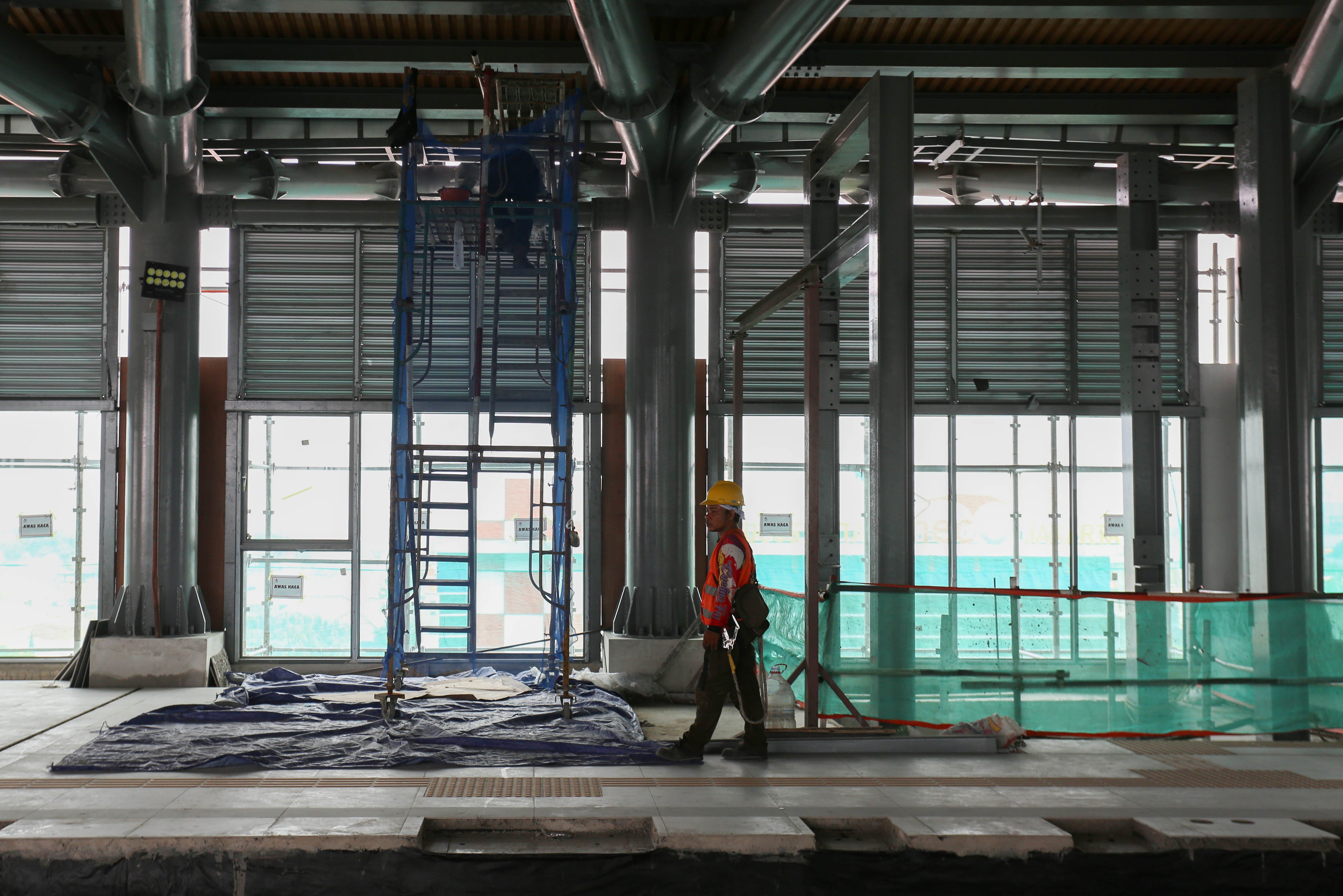 Pekerja menyelesaikan pembangunan Stasiun LRT Rawamangun, Jakarta, Rabu (30/10/2024). PT Jakarta Propertindo (Perseroda) (Jakpro) mencatat progres pembangunan Stasiun Rawamangun telah mencapai 46,24 persen, sementara itu secara keseluruhan proyek LRT Jakarta Fase 1B jalur Velodrome - Manggarai sudah mencakup progres hingga 33,45 persen dan ditargetkan akan selesai pada kuartal III tahun 2026.