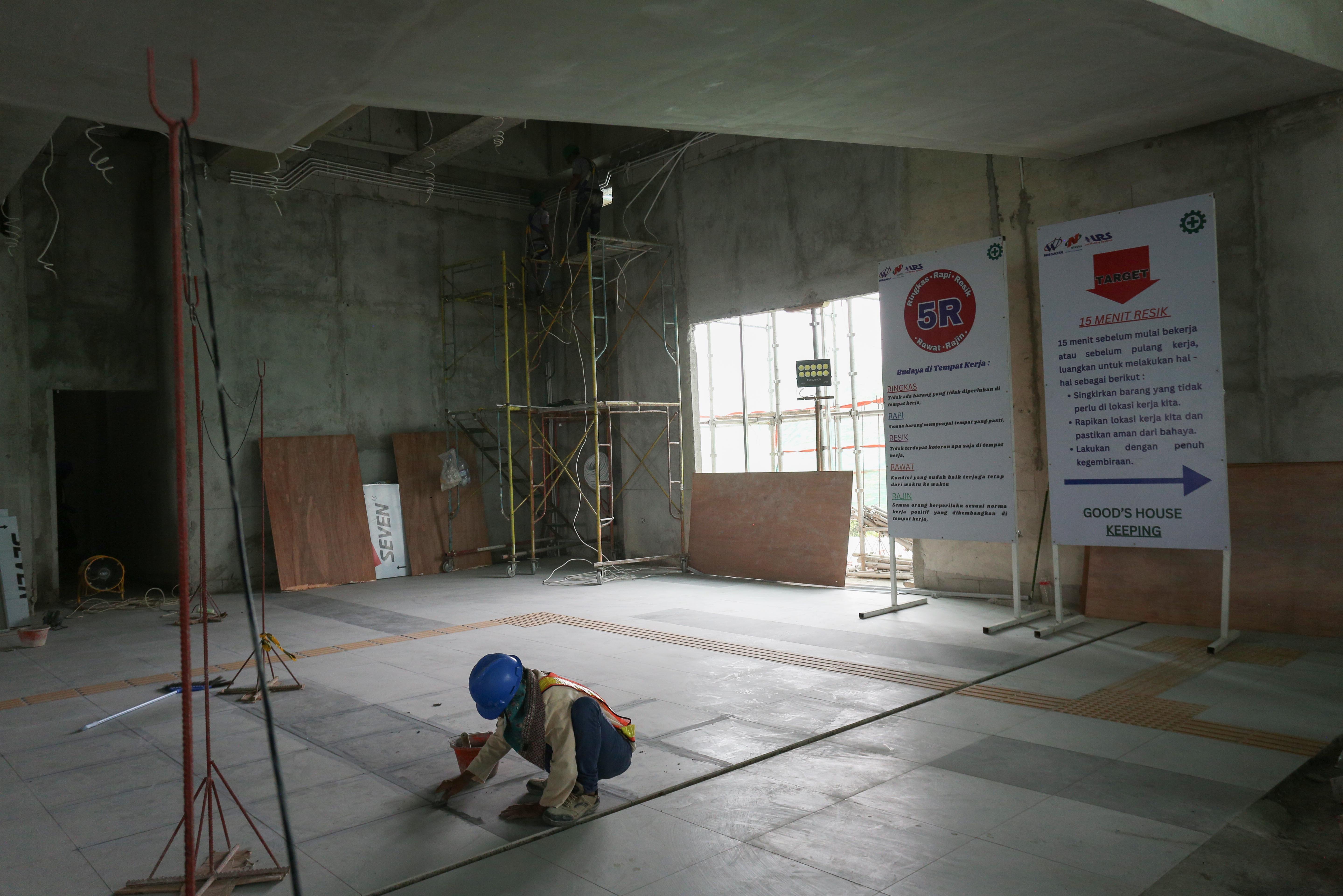 Pekerja menyelesaikan pembangunan Stasiun LRT Rawamangun, Jakarta, Rabu (30/10/2024). PT Jakarta Propertindo (Perseroda) (Jakpro) mencatat progres pembangunan Stasiun Rawamangun telah mencapai 46,24 persen, sementara itu secara keseluruhan proyek LRT Jakarta Fase 1B jalur Velodrome - Manggarai sudah mencakup progres hingga 33,45 persen dan ditargetkan akan selesai pada kuartal III tahun 2026.