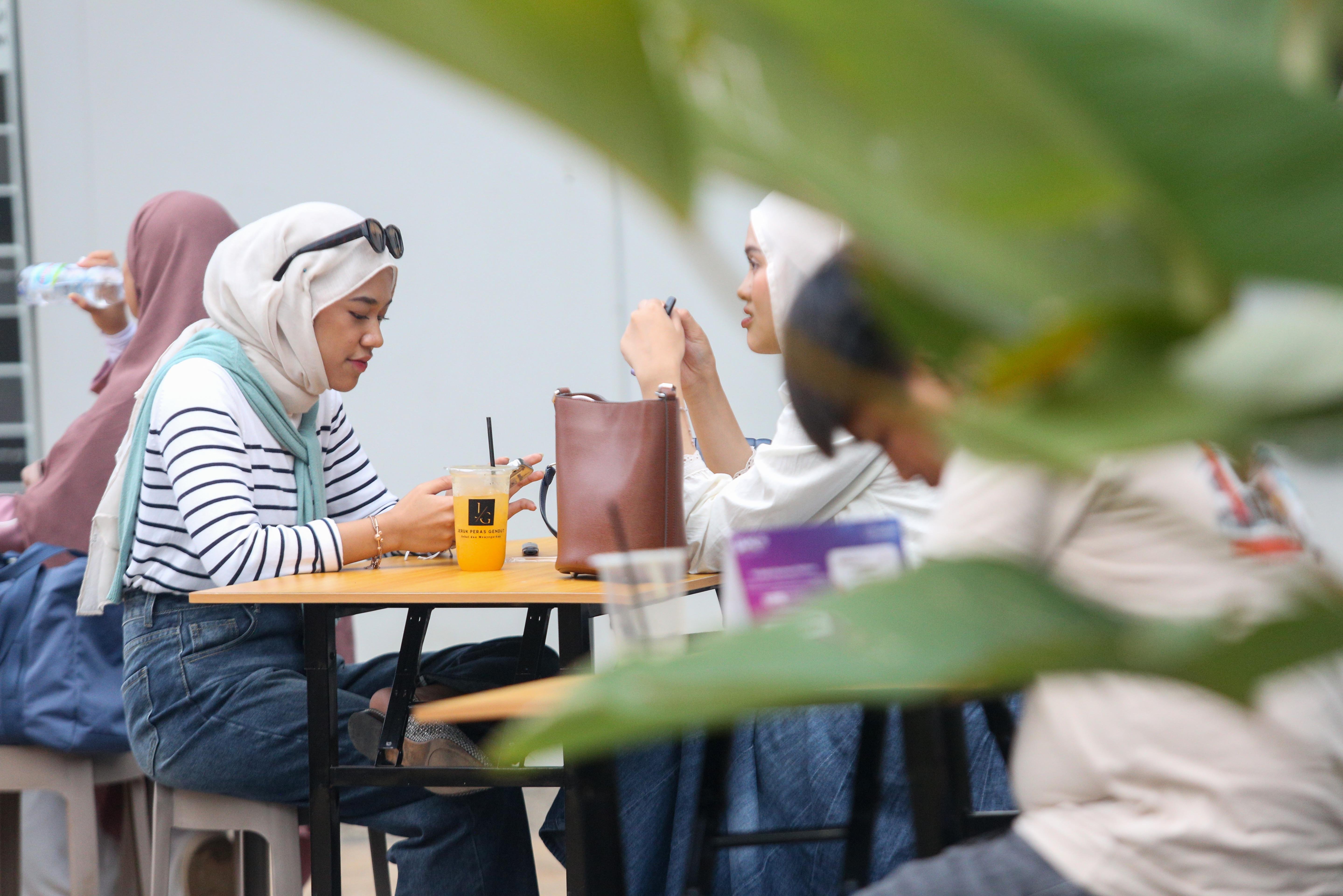 Pengunjung menikmati minuman yang telah dibeli pada Festival Kuliner Jajanan Asia di Taman Literasi Martha Christina Tiahahu, Blok M, Jakarta Selatan, Kamis (7/11/2024). Festival kuliner yang menghadirkan makanan khas Asia mulai dari nasi goreng, nasi kandar, gyoza, dakkochi, mie kari hingga bungeoppang ini digelar hingga 10 November mendatang.