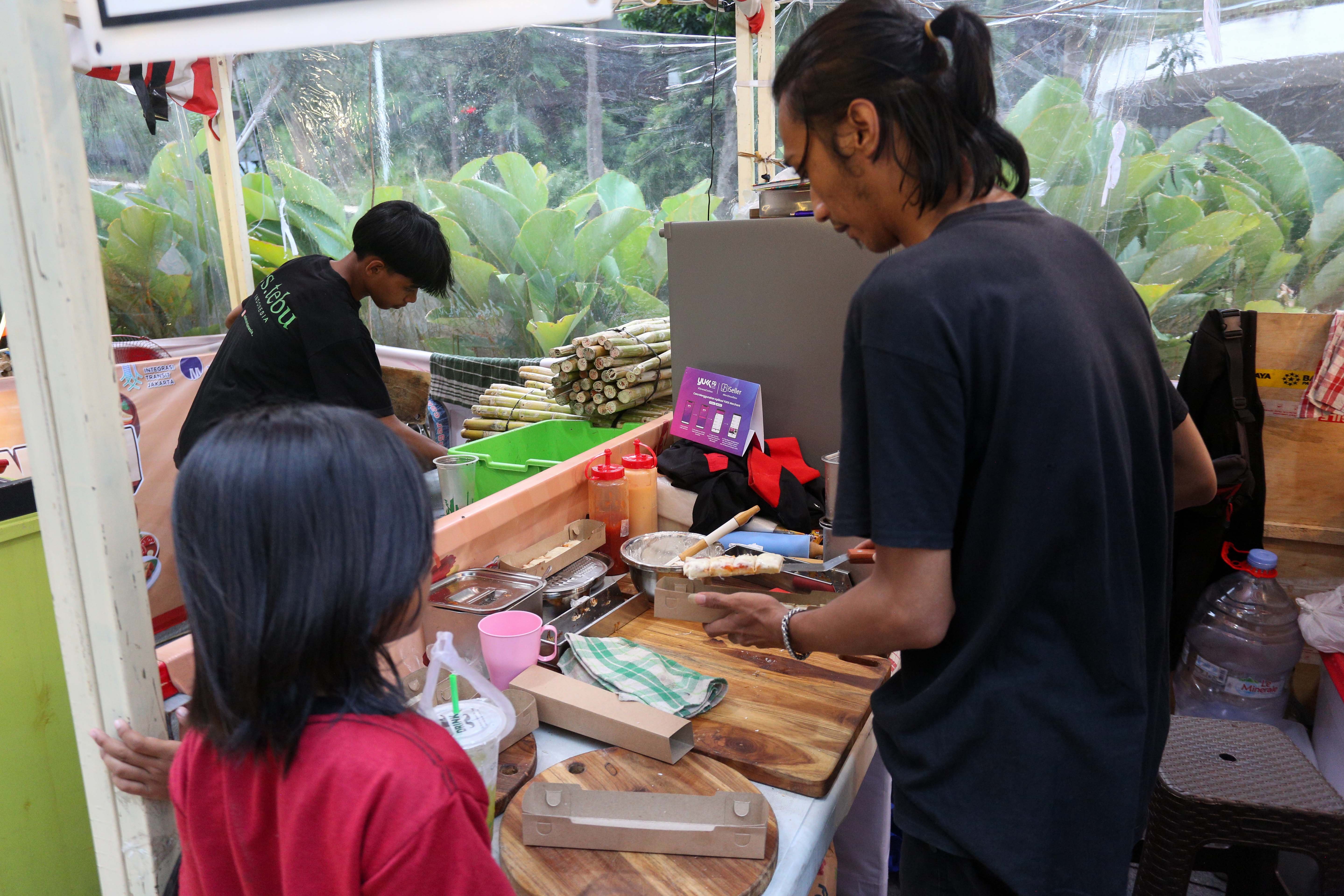 Pedagang menyajikan makanan pesanan pengunjung pada Festival Kuliner Jajanan Asia di Taman Literasi Martha Christina Tiahahu, Blok M, Jakarta Selatan, Kamis (7/11/2024). Festival kuliner yang menghadirkan makanan khas Asia mulai dari nasi goreng, nasi kandar, gyoza, dakkochi, mie kari hingga bungeoppang ini digelar hingga 10 November mendatang.