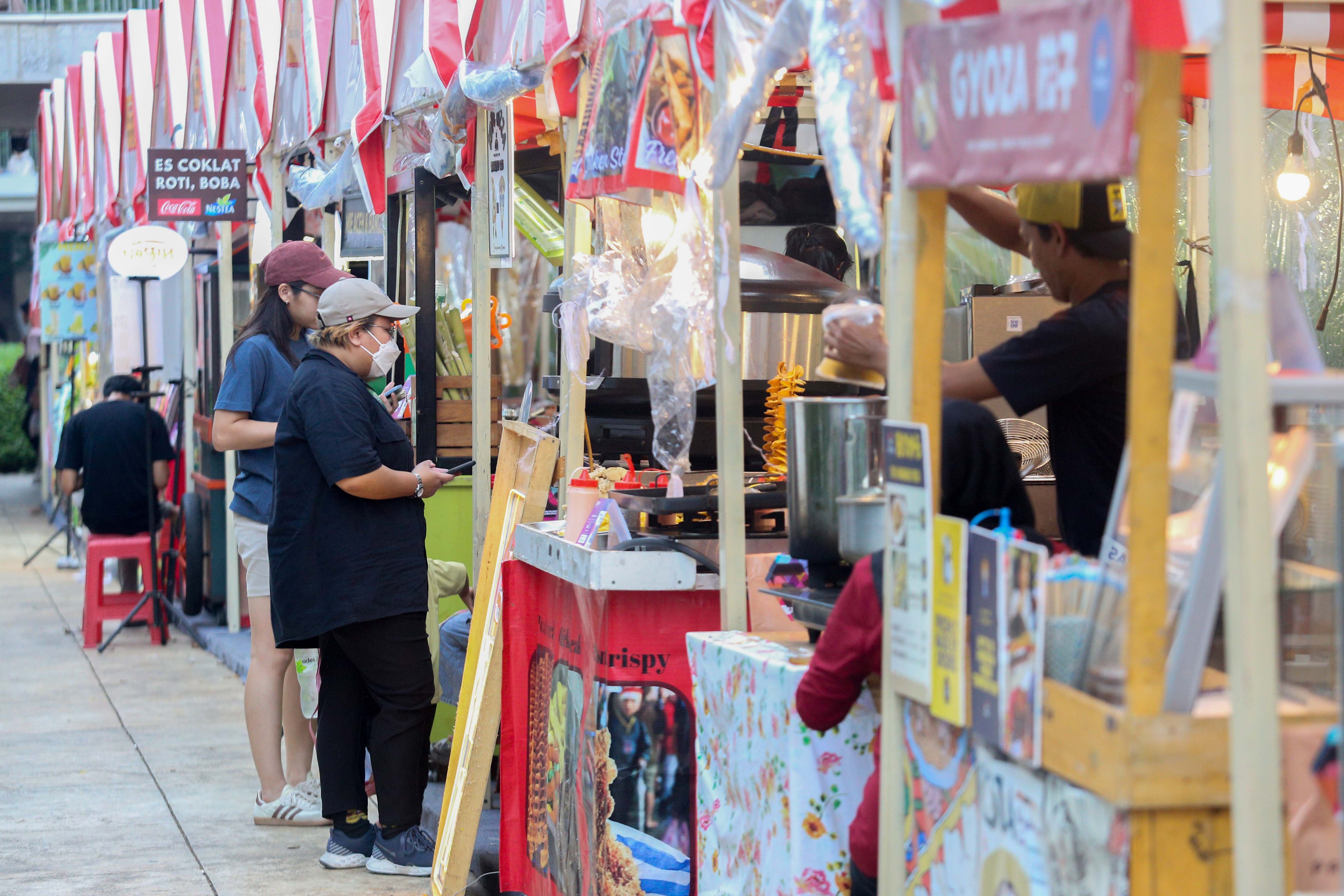 Pengunjung memesan makanan pada Festival Kuliner Jajanan Asia di Taman Literasi Martha Christina Tiahahu, Blok M, Jakarta Selatan, Kamis (7/11/2024). Festival kuliner yang menghadirkan makanan khas Asia mulai dari nasi goreng, nasi kandar, gyoza, dakkochi, mie kari hingga bungeoppang ini digelar hingga 10 November mendatang.