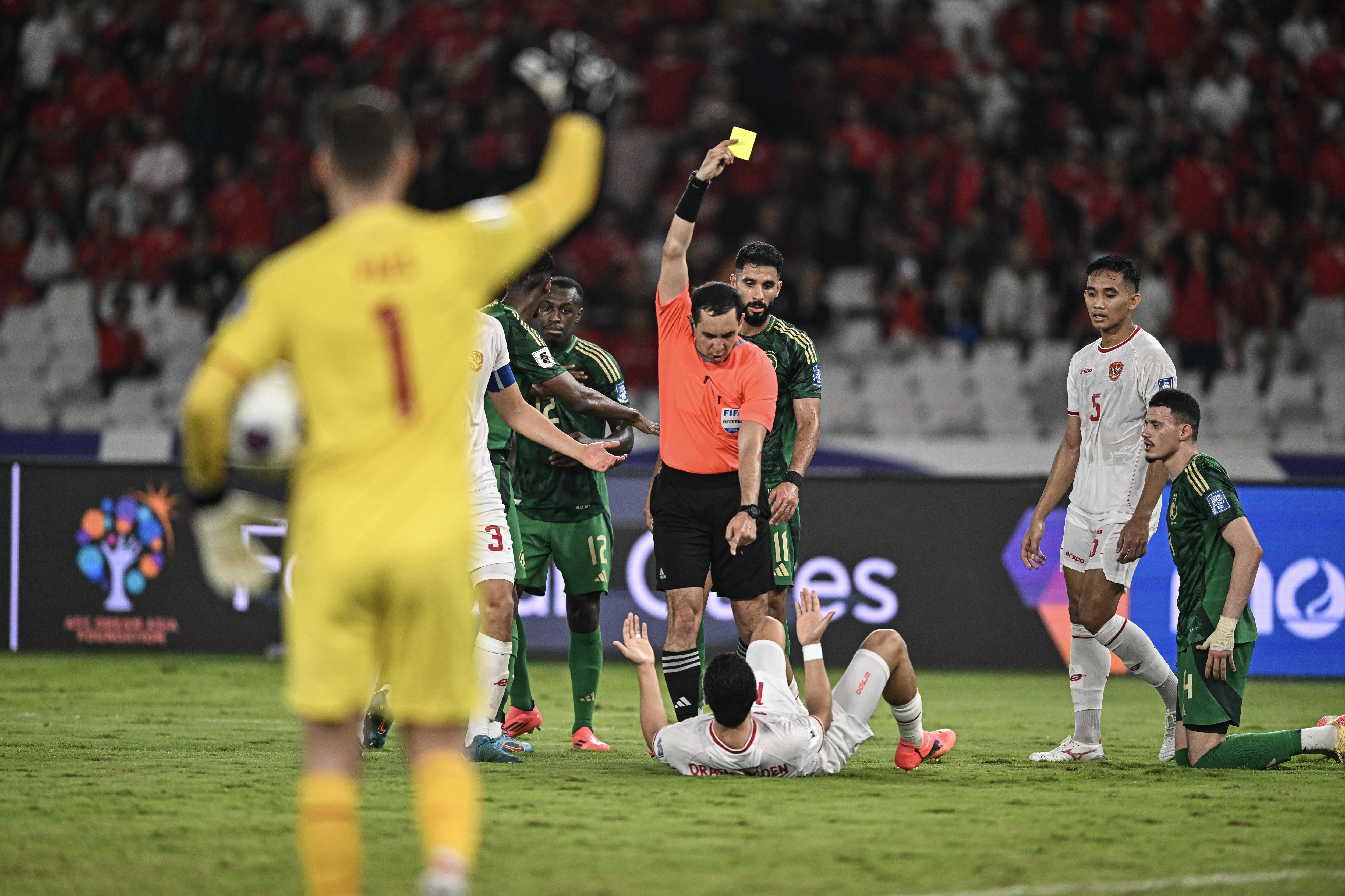 Wasit asal Uzbekistan Rustam Lutfullin (tengah) memberikan kartu kuning kepada pesepak bola Timnas Indonesia Ragnar Oratmangoen (bawah) saat melawan Timnas Arab Saudi pada pertandingan Grup C putaran ketiga Kualifikasi Piala Dunia 2026 Zona Asia di Stadion Utama Gelora Bung Karno, Senayan, Jakarta, Selasa (19/11/2024). Indonesia berhasil mengalahkan Arab Saudi dengan skor 2-0. 