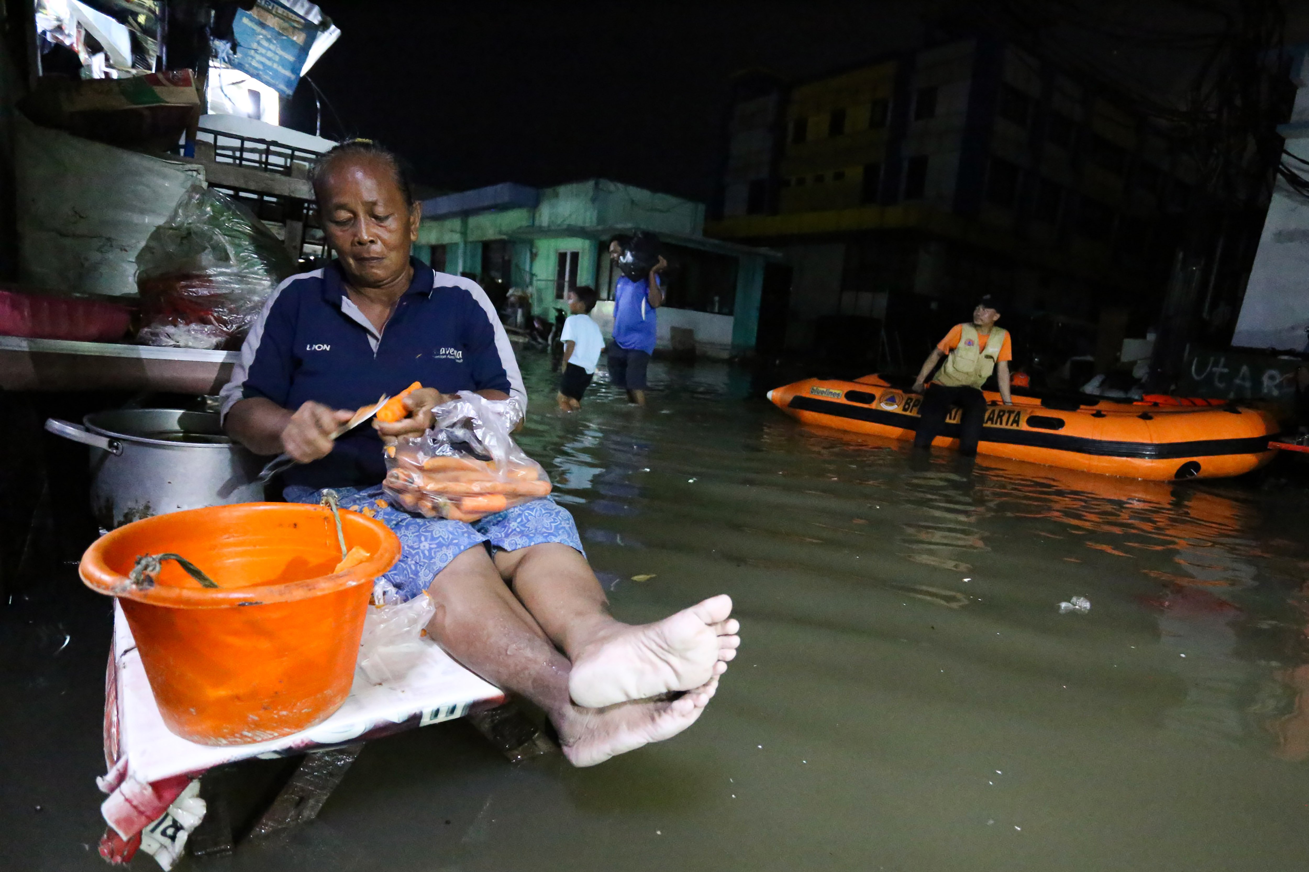 Seorang warga mengupas sayuran saat banjir rob di kawasan Muara Angke, Jakarta, Senin (18/11/2024). Menurut BPBD Jakarta rob yang melanda sejumlah wilayah di Jakarta Utara tersebut karena fenomena pasang maksimum air laut bersamaan dengan fase bulan baru yang berpotensi meningkatkan ketinggian pasang air laut maksimum berupa banjir pesisir di wilayah pesisir utara Jakarta. 