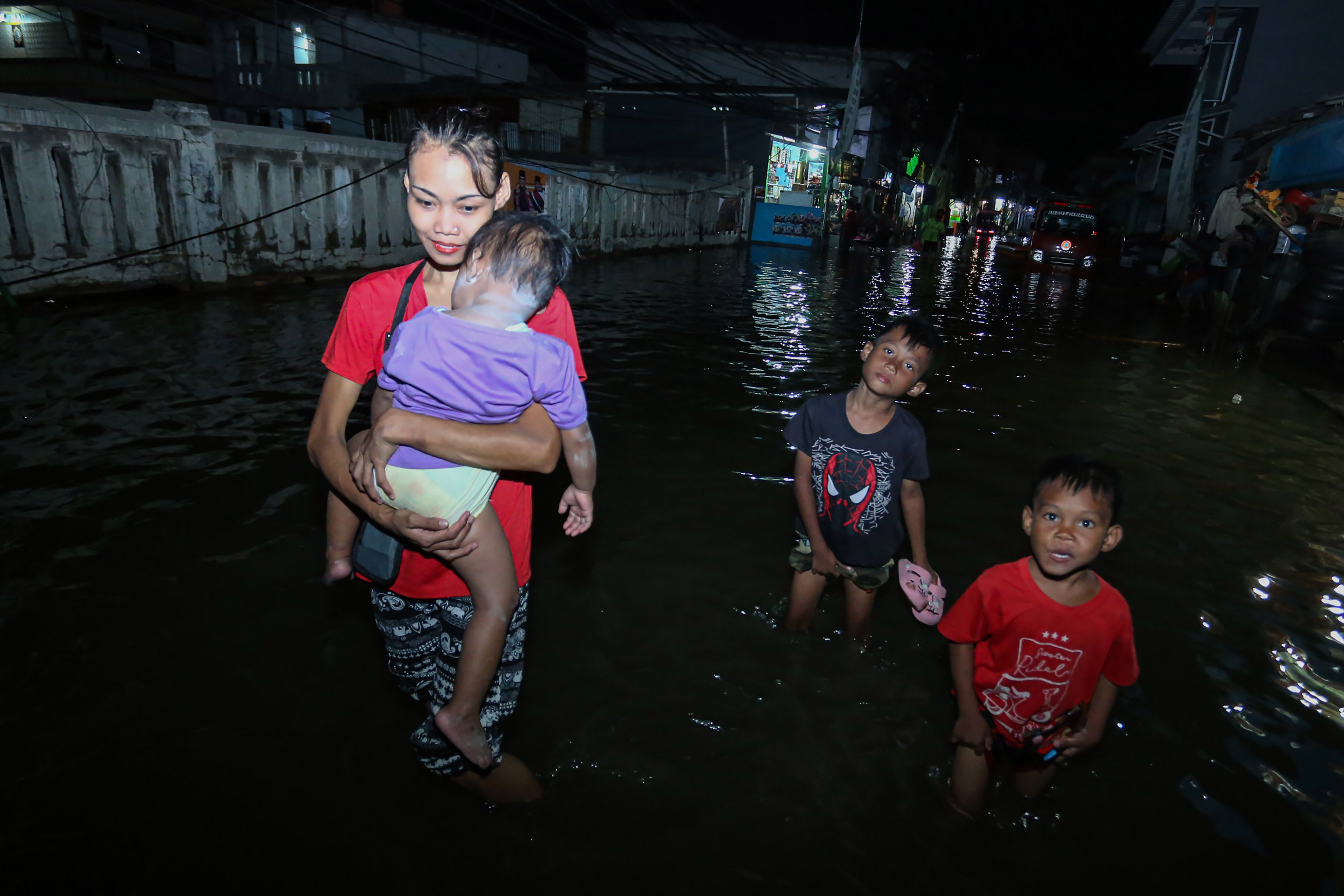 Sejumlah warga berjalan saat banjir rob di kawasan Muara Angke, Jakarta, Senin (18/11/2024). Menurut BPBD Jakarta rob yang melanda sejumlah wilayah di Jakarta Utara tersebut karena fenomena pasang maksimum air laut bersamaan dengan fase bulan baru yang berpotensi meningkatkan ketinggian pasang air laut maksimum berupa banjir pesisir di wilayah pesisir utara Jakarta. 