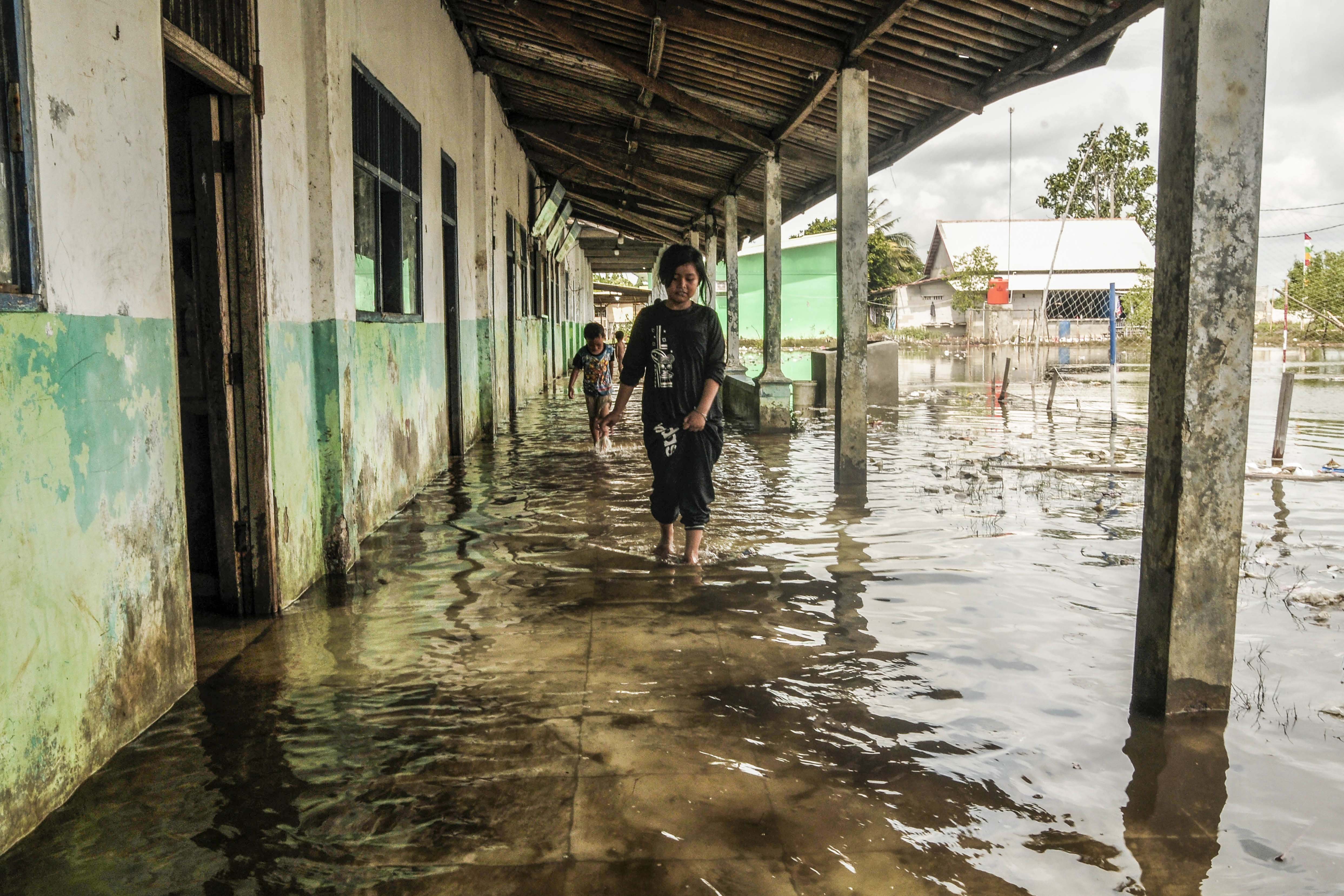 Anak-anak bermain di Madrasah Ibtidaiyah (MI) Al-Hidayah Al Khairiyah terdampak banjir rob di Kampung Sembilangan, Tarumajaya, Kabupaten Bekasi, Jawa Barat, Senin (18/11/2024). Banjir rob akibat pasang air laut telah menggenangi wilayah tersebut selama empat hari dengan ketinggian 30-50 cm.