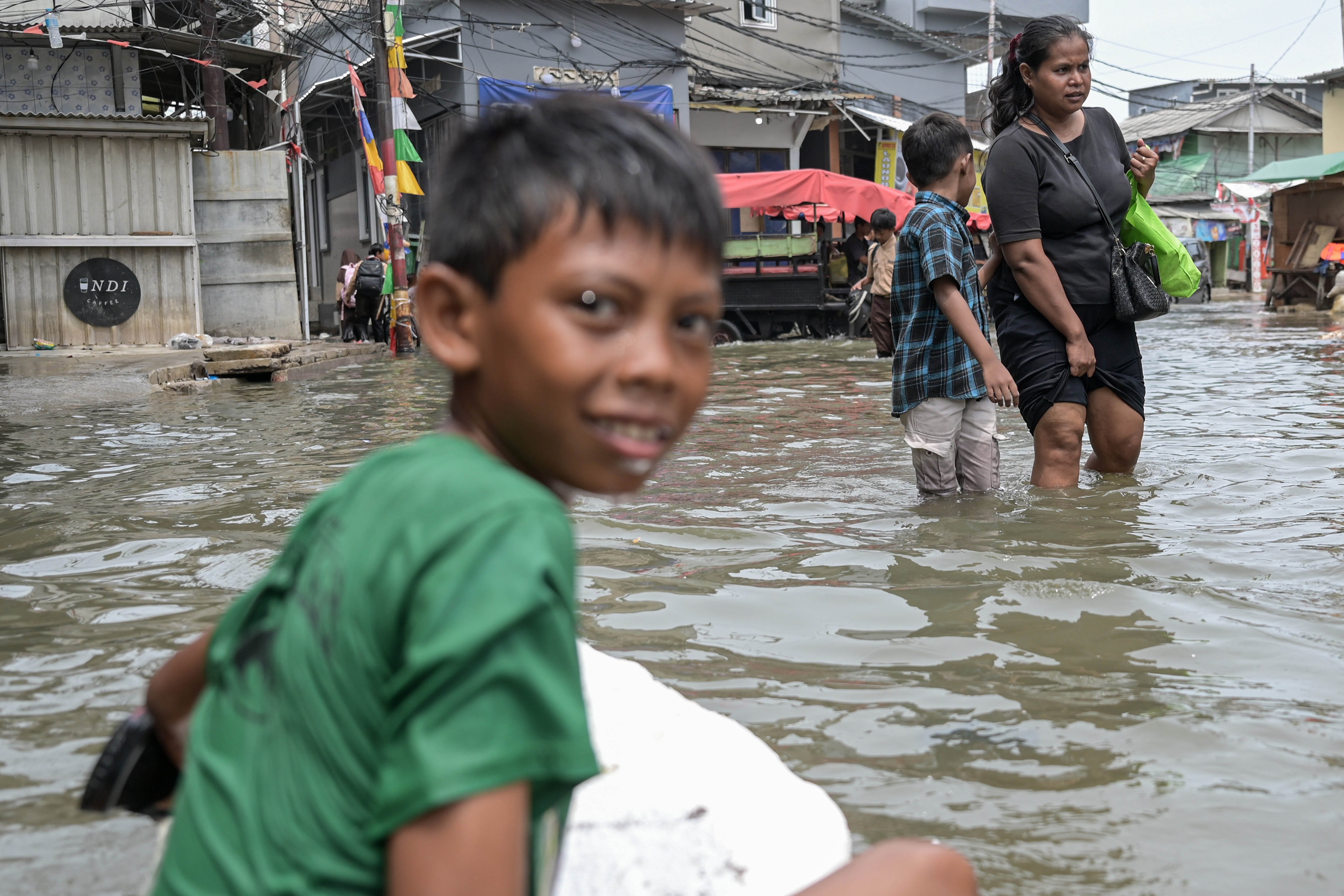 Warga melintas di tengah banjir rob di Muara Angke , Jakarta, Rabu (20/11/2024). Memasuki hari keenam, banjir setinggi hingga 50 sentimeter akibat pasangnya air laut tersebut diprediksi masih akan terjadi sampai 21 November 2024. 