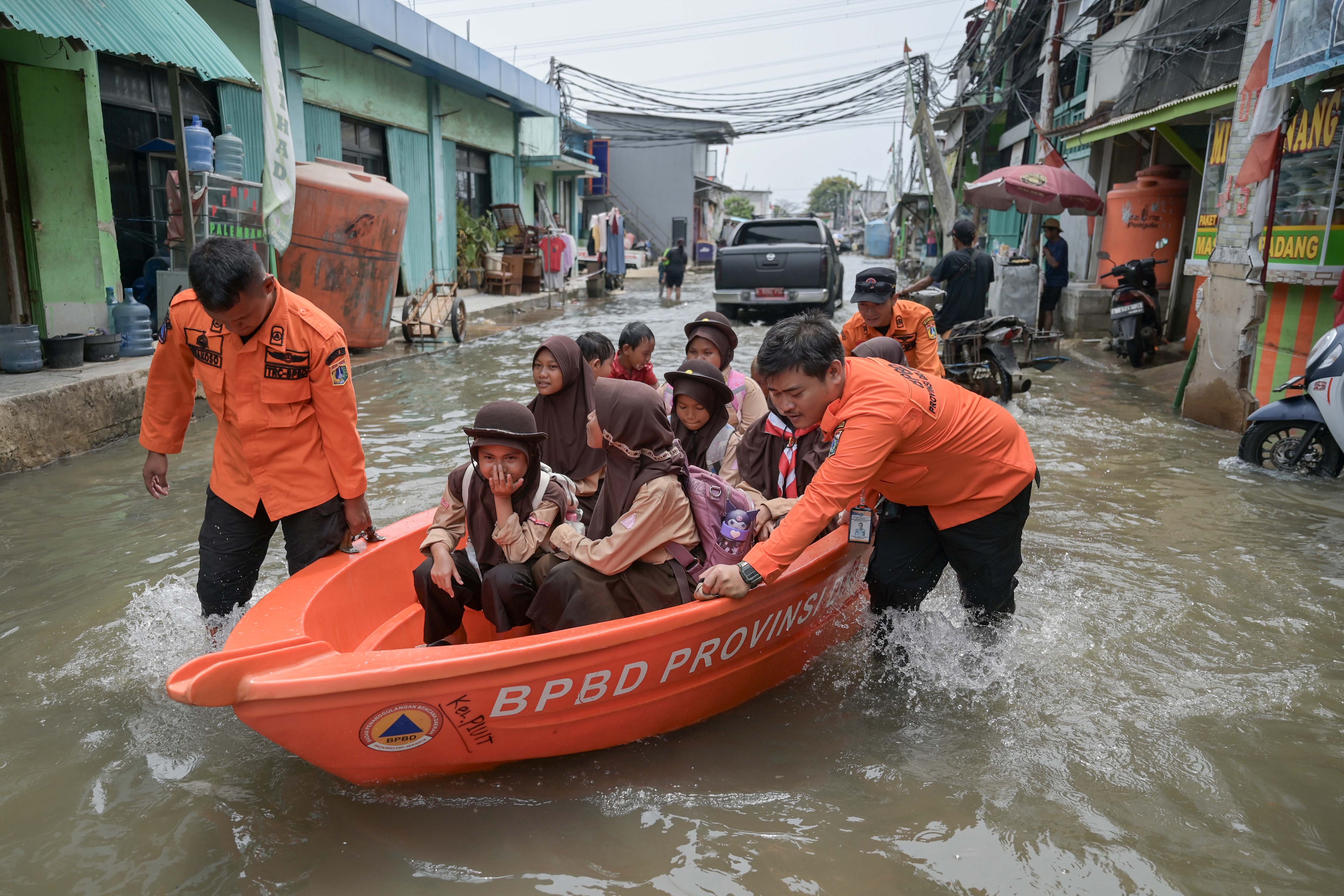 Petugas BPBD DKI Jakarta membawa pelajar menggunakan perahu karet di tengah banjir rob di Muara Angke , Jakarta, Rabu (20/11/2024). Memasuki hari keenam, banjir setinggi hingga 50 sentimeter akibat pasangnya air laut tersebut diprediksi masih akan terjadi sampai 21 November 2024.