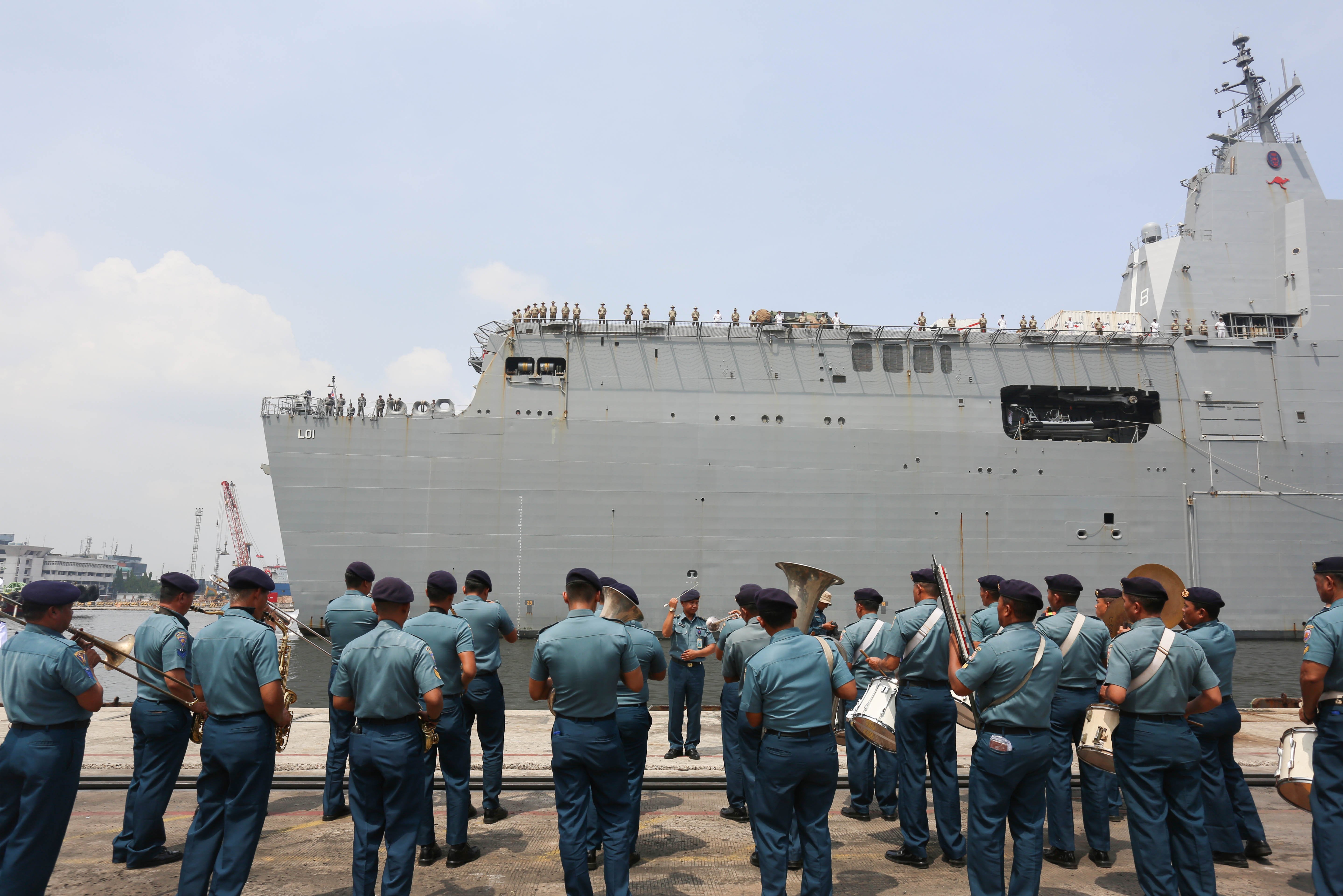 Penampilan marching band dari personel TNI Angkata Laut saat menyambut Kapal HMAS Adelaide yang tiba di Dermaga JICT 2, Pelabuhan Tanjung Priok, Jakarta Utara, Selasa (19/11/2024). Kunjungan Kapal HMAS Adelaide tersebut dalam rangka mempererat kerja sama antara Tentara Nasional Indonesia (TNI) dengan Angkatan Pertahanan Australia (ADF) dalam mendukung pertukaran pengetahuan tentang kedokteran militer, perempuan, perdamaian dan keamanan. 