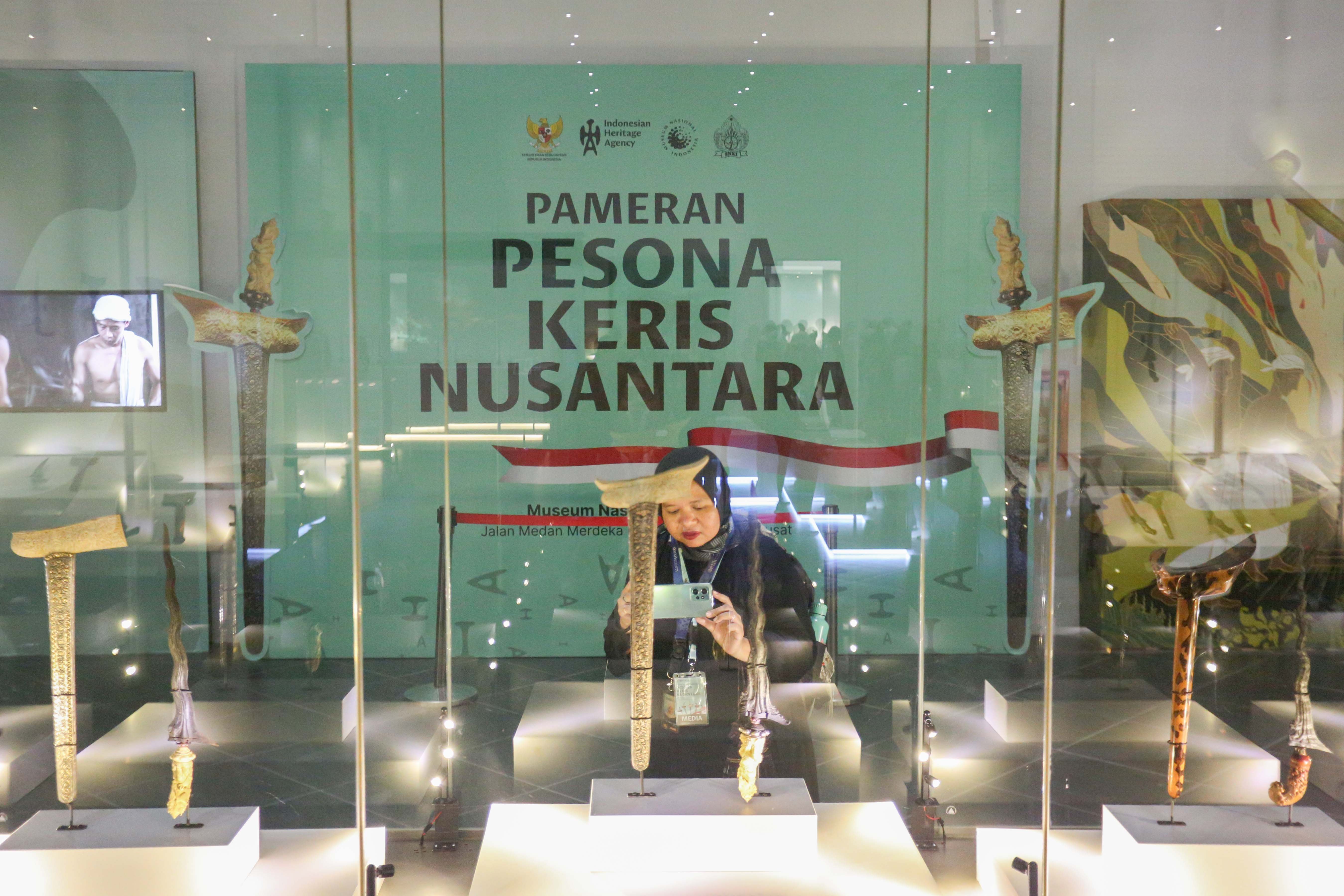 Pengunjung memotret keris yang ditampilkan pada Pameran Pesona Keris Nusantara di Museum Nasional, Jakarta, Senin (25/11/2024). Pameran yang digelar dalam rangka memperingati 19 tahun pengakuan UNESCO terhadap Keris Indonesia sebagai Karya Agung Budaya Dunia tersebut menghadirkan lebih dari 200 keris dari berbagai daerah dan berlangsung hingga 31 Desember 2024.
