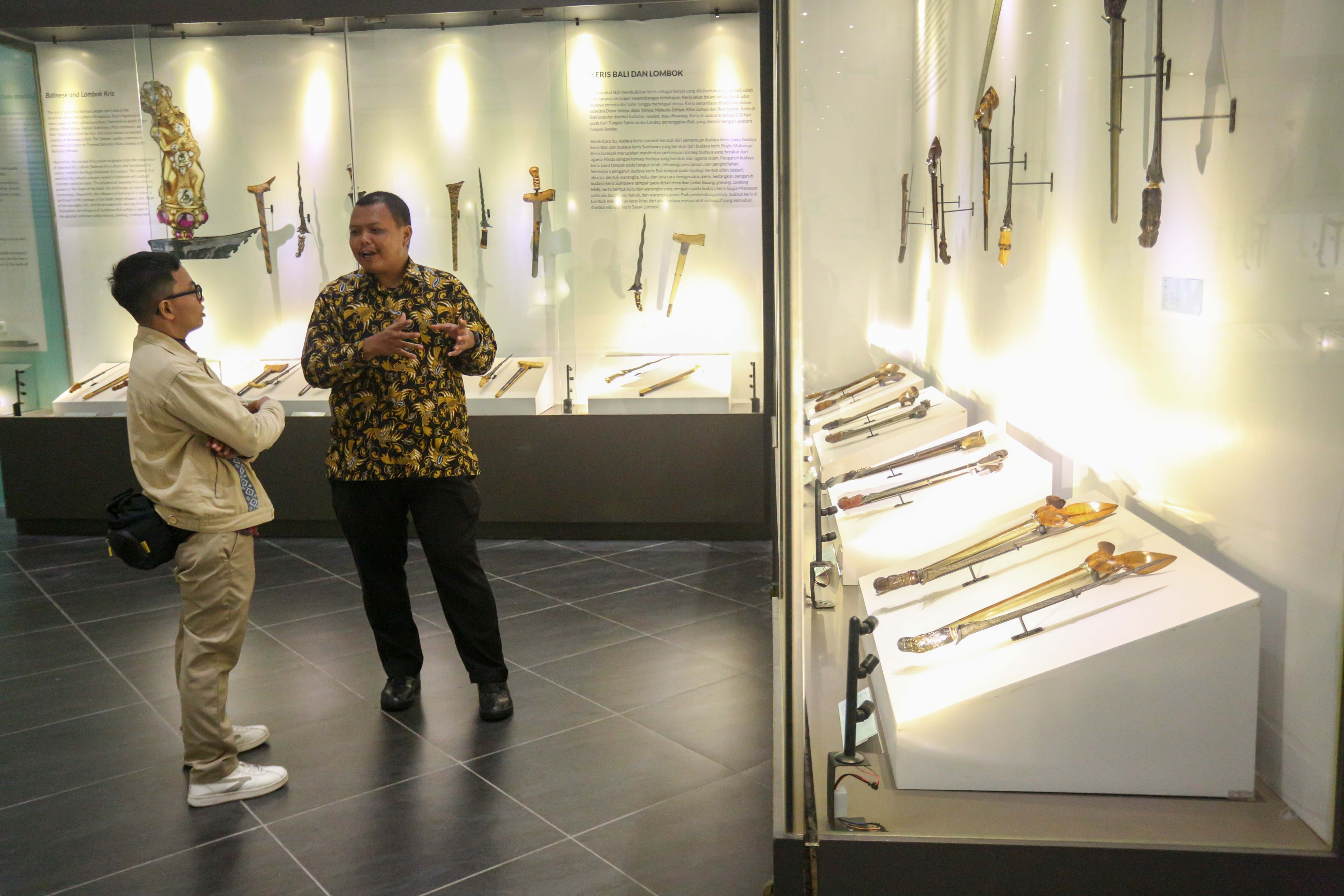 Petugas (kanan) memberikan penjelasan mengenai keris yang ditampilkan kepada pengunjung saat Pameran Pesona Keris Nusantara di Museum Nasional, Jakarta, Senin (25/11/2024). Pameran yang digelar dalam rangka memperingati 19 tahun pengakuan UNESCO terhadap Keris Indonesia sebagai Karya Agung Budaya Dunia tersebut menghadirkan lebih dari 200 keris dari berbagai daerah dan berlangsung hingga 31 Desember 2024.
