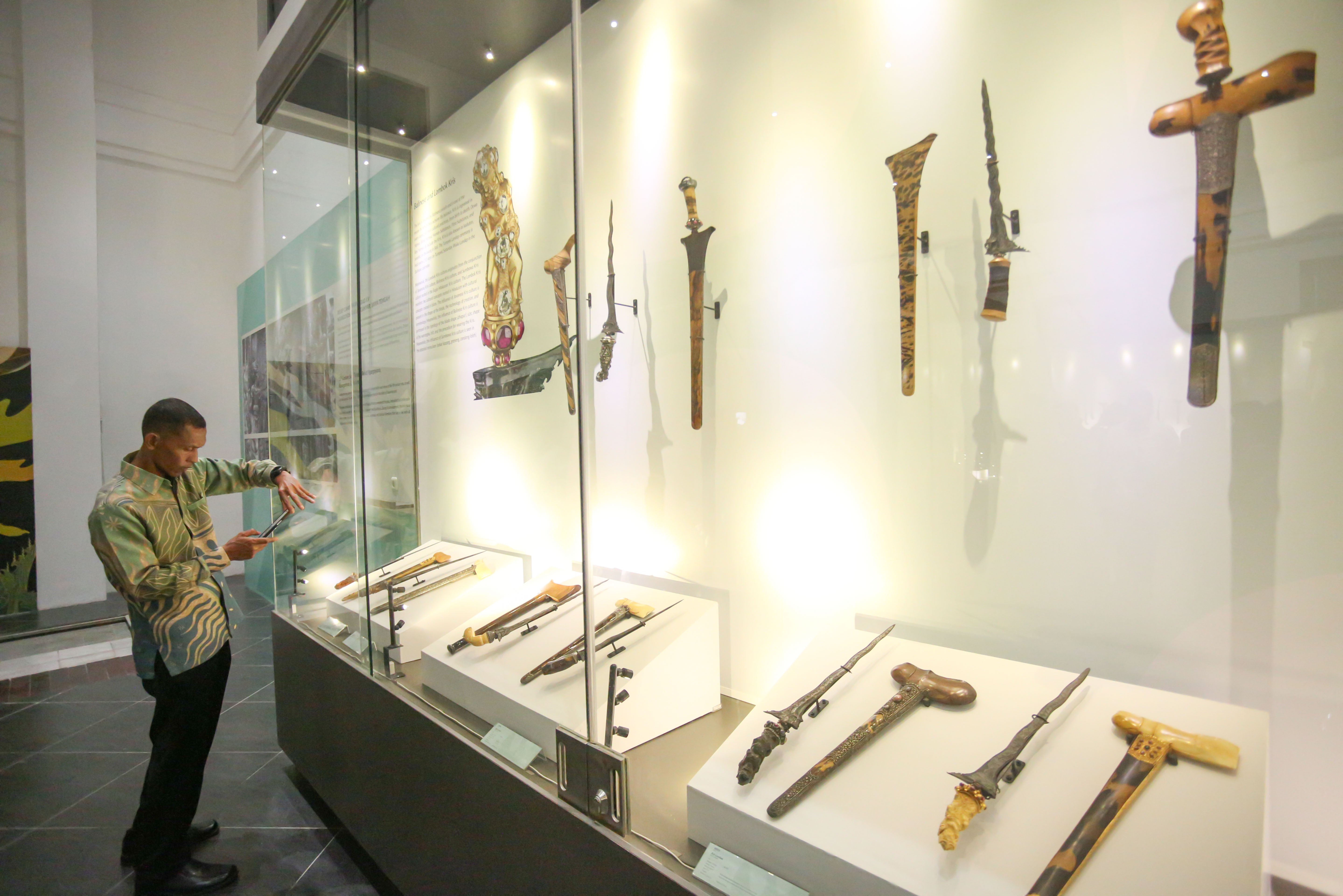 Pengunjung memotret keris yang ditampilkan pada Pameran Pesona Keris Nusantara di Museum Nasional, Jakarta, Senin (25/11/2024). Pameran yang digelar dalam rangka memperingati 19 tahun pengakuan UNESCO terhadap Keris Indonesia sebagai Karya Agung Budaya Dunia tersebut menghadirkan lebih dari 200 keris dari berbagai daerah dan berlangsung hingga 31 Desember 2024.