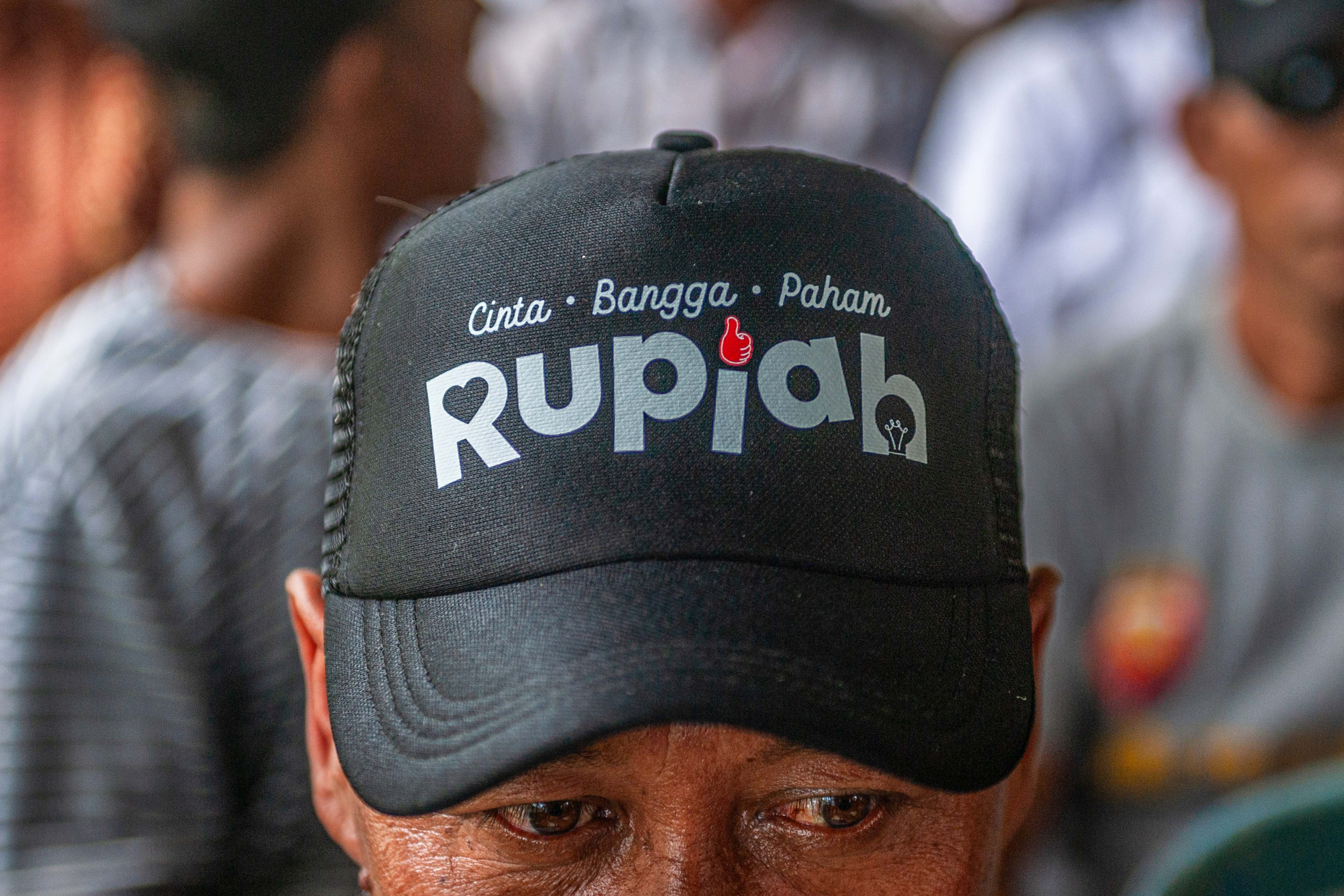 Warga mengenakan topi cinta bangga paham rupiah saat Ekspedisi Rupiah Karimunjawa (ERK-2024) di Pulau Genting, Kepulauan Karimunjawa, Jawa Tengah.