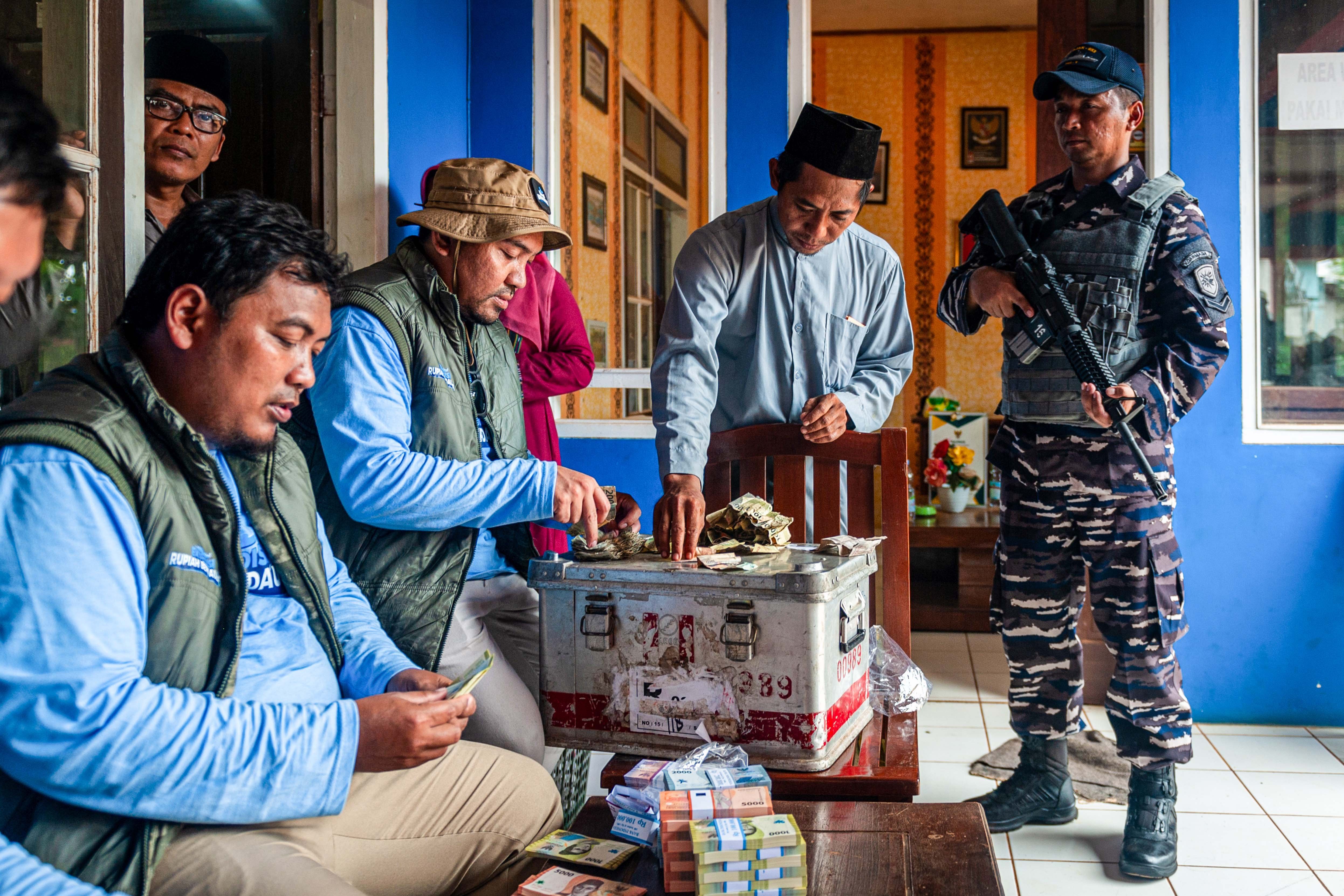Pegawai KPw BI Jateng melayani warga yang menukarkan uang lusuh dengan uang baru saat kas keliling penukaran uang baru saat Ekspedisi Rupiah Karimunjawa (ERK-2024) di Pulau Parang, Kepulauan Karimunjawa, Jawa Tengah.