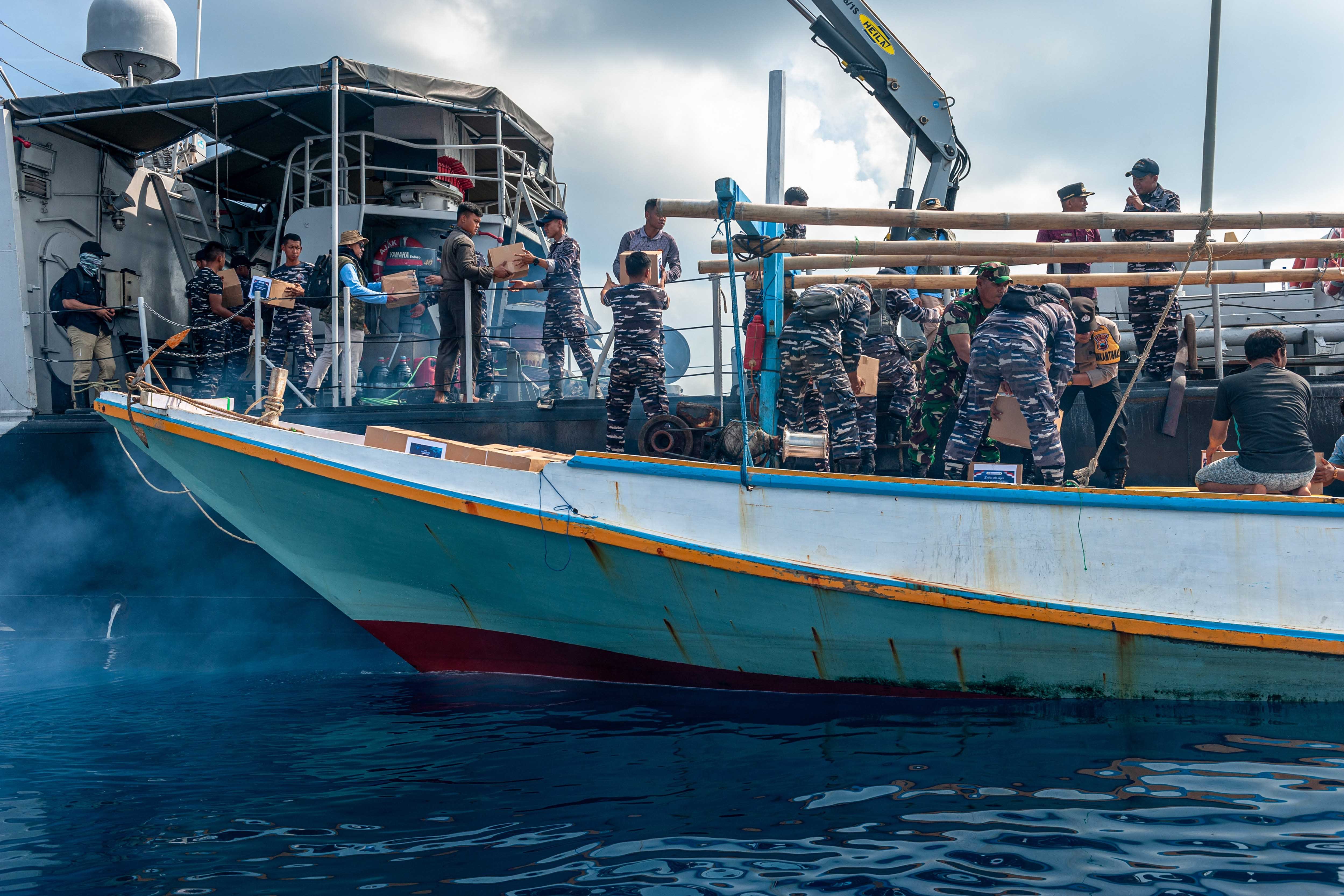 Personel KRI Ajak-653 bersama tim ERK-2024 melakukan debarkasi paket bantuan sembako program sosial BI dari KRI Ajak-653 ke kapal nelayan untuk kemudian didistribusikan kepada warga saat pelayaran Ekspedisi Rupiah Karimunjawa (ERK-2024).