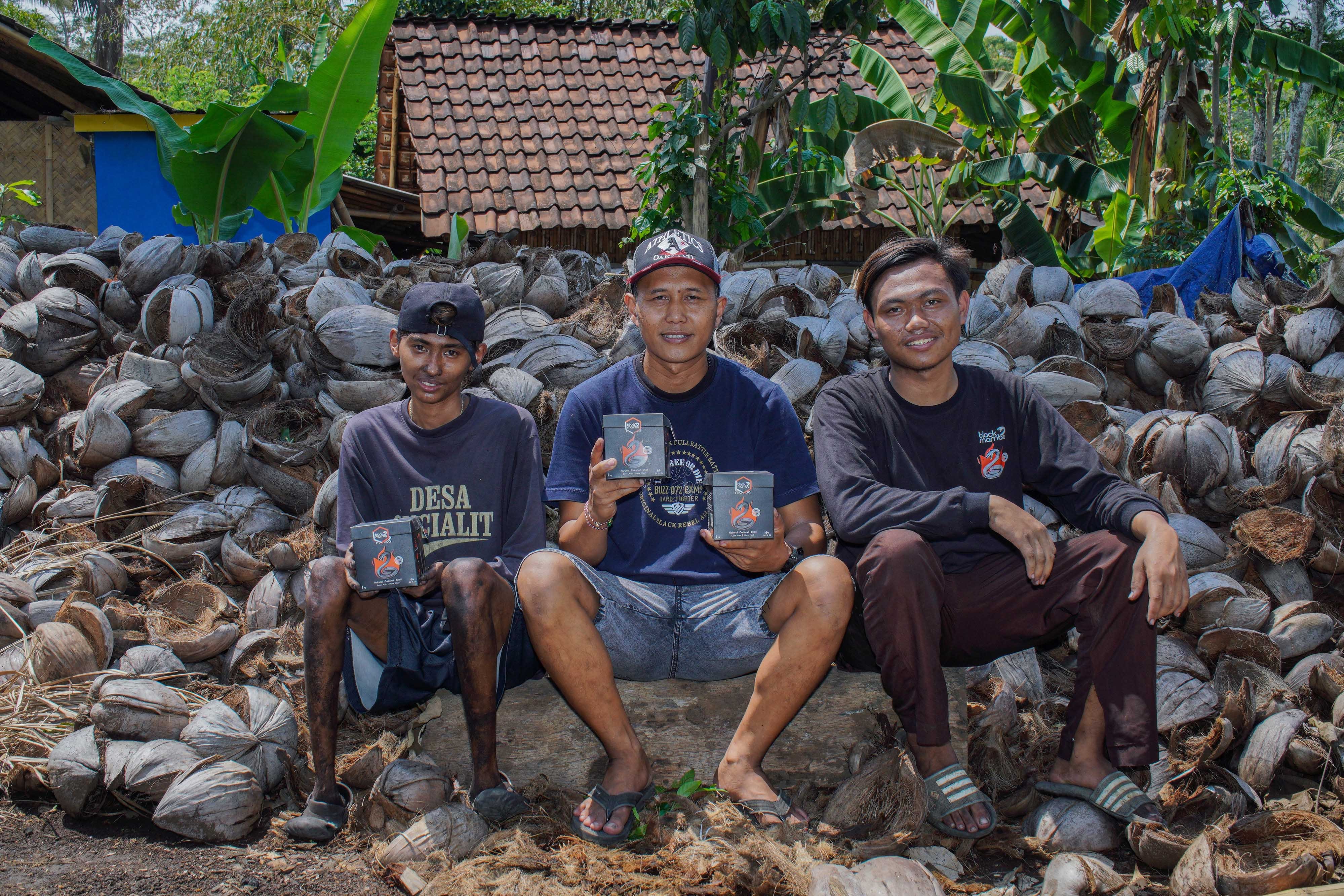 Nur Hasan (tengah) bersama pekerja memperlihatkan arang briket berbahan dasar limbah kelapa yang siap dikirim ke Turki di Desa Gucialit, Lumajang, Jawa Timur.