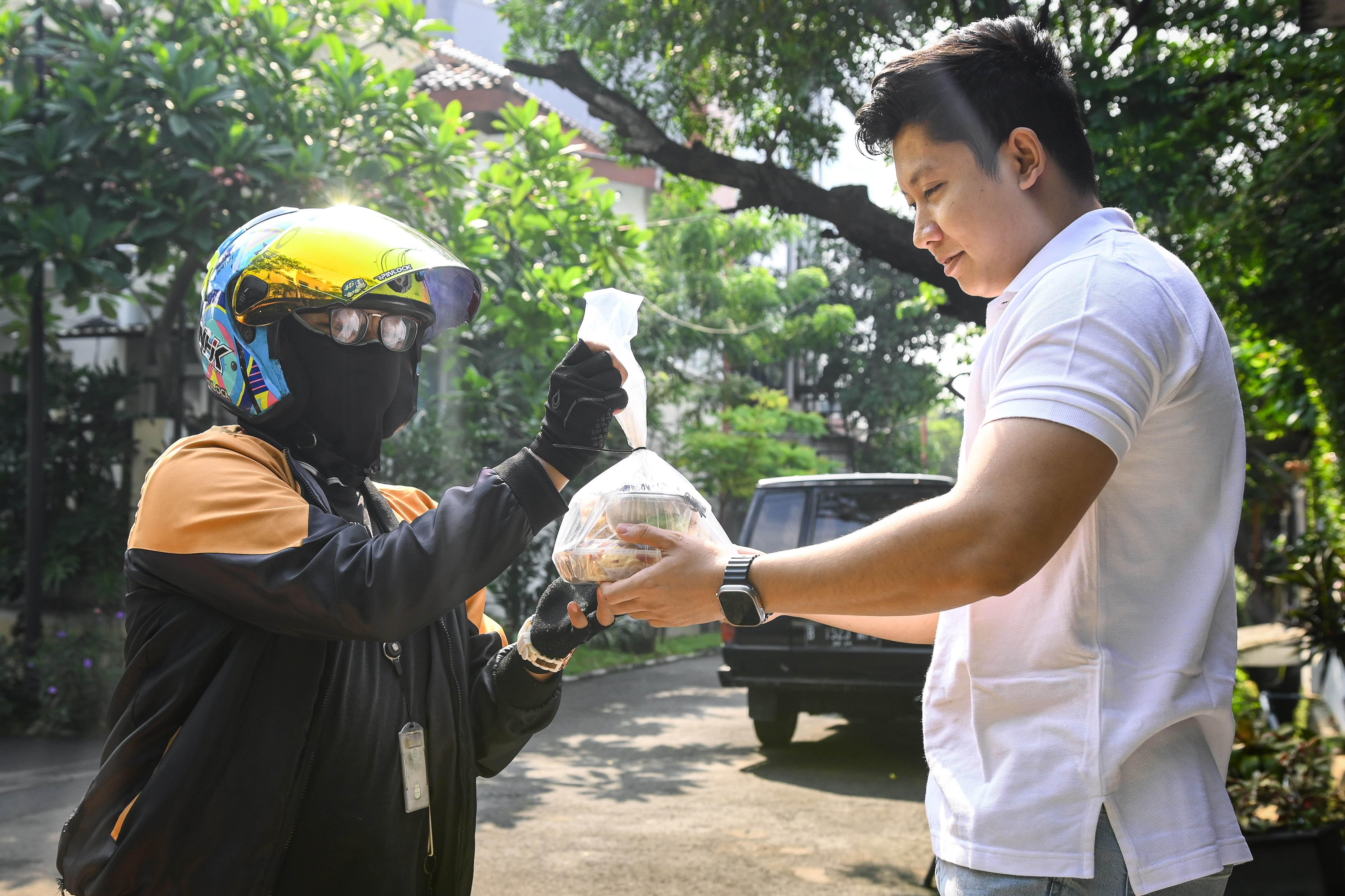 Pekerja mengantar makanan sehat ke rumah pelanggan di kawasan Bintaro, Tangerang Selatan.