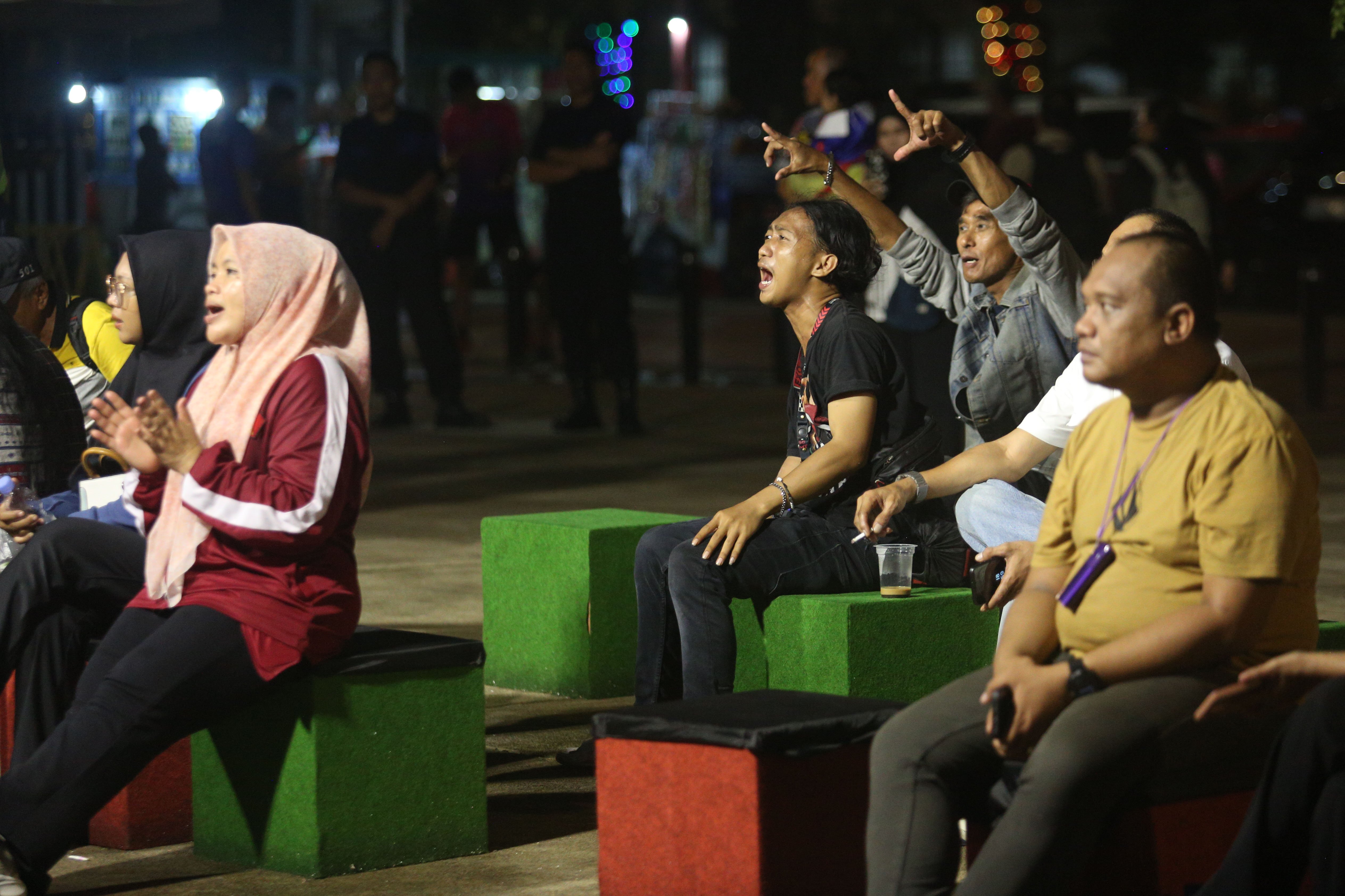 Sejumlah pengunjung bernyanyi saat Moscato Band tampil pada Pasar Kreatif Natal di Lapangan Banteng, Jakarta, Senin (23/12/2024). Kegiatan yang digelar dalam rangka menyambut Hari Raya Natal 2024 tersebut menghadirkan berbagai acara menarik mulai dari 70 stan UMKM makanan ringan dan produk kerajinan tangan, paduan suara kidung natal hingga penampilan musik dari Krisna Trias dan Moscato Band. 