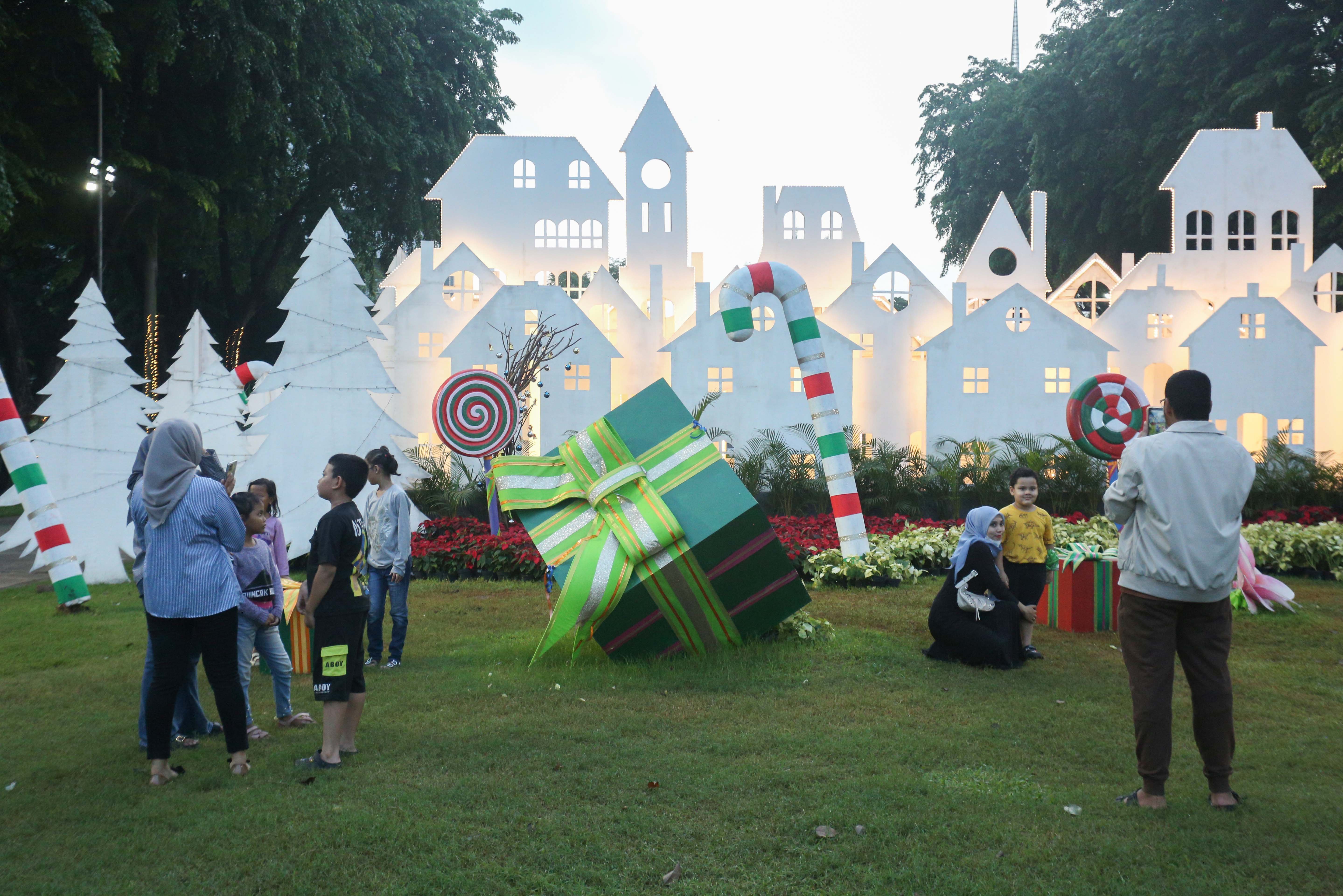 Pengunjung mengabadikan foto dengan latar belakang dekorasi Natal saat berkunjung ke Pasar Kreatif Natal di Lapangan Banteng, Jakarta, Senin (23/12/2024). Kegiatan yang digelar dalam rangka menyambut Hari Raya Natal 2024 tersebut menghadirkan berbagai acara menarik mulai dari 70 stan UMKM makanan ringan dan produk kerajinan tangan, paduan suara kidung natal hingga penampilan musik dari Krisna Trias dan Moscato Band. 