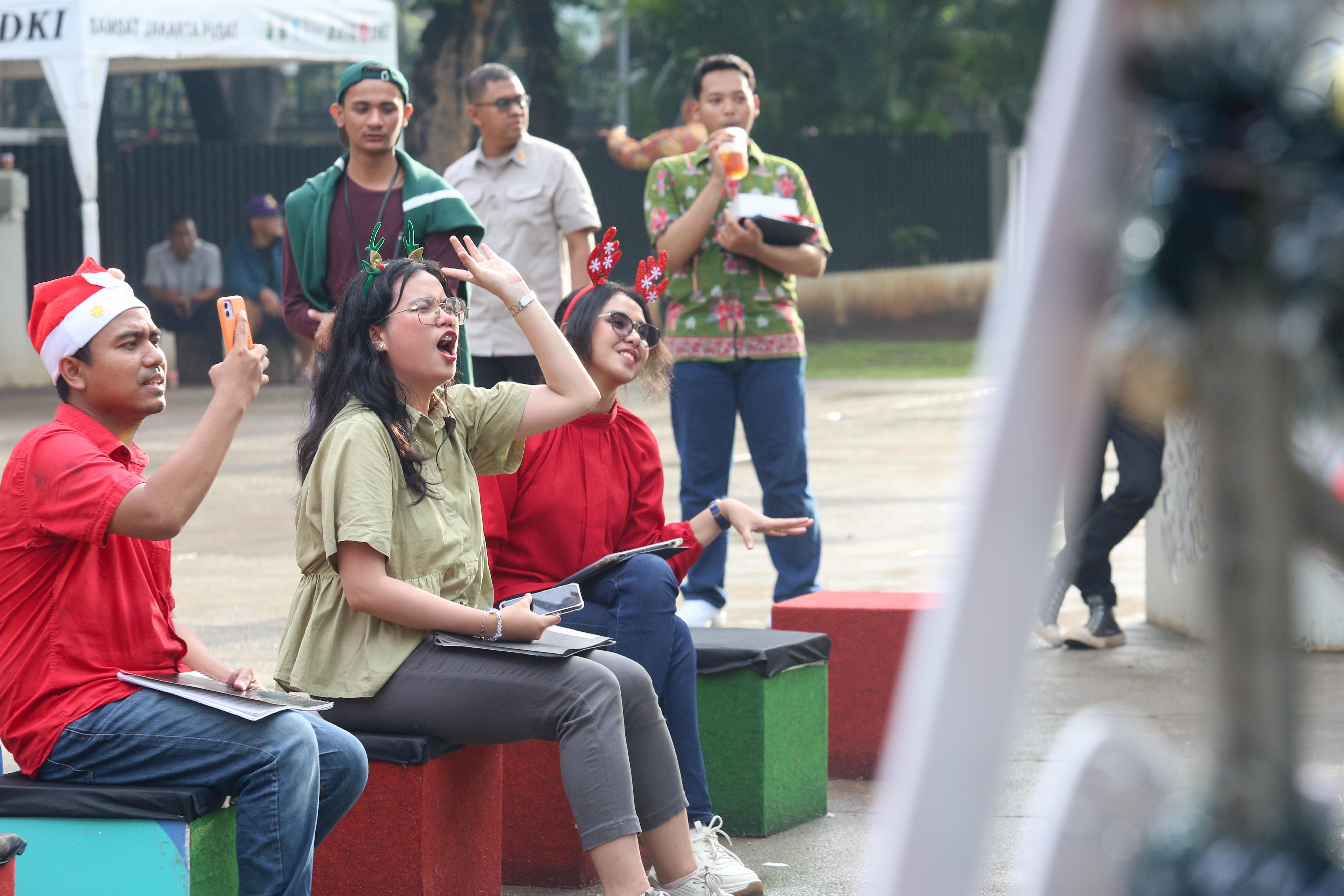 Pengunjung bernyanyi saat kelompok paduan suara membawakan kidung natal pada Pasar Kreatif Natal di Lapangan Banteng, Jakarta, Senin (23/12/2024). Kegiatan yang digelar dalam rangka menyambut Hari Raya Natal 2024 tersebut menghadirkan berbagai acara menarik mulai dari 70 stan UMKM makanan ringan dan produk kerajinan tangan, paduan suara kidung natal hingga penampilan musik dari Krisna Trias dan Moscato Band.