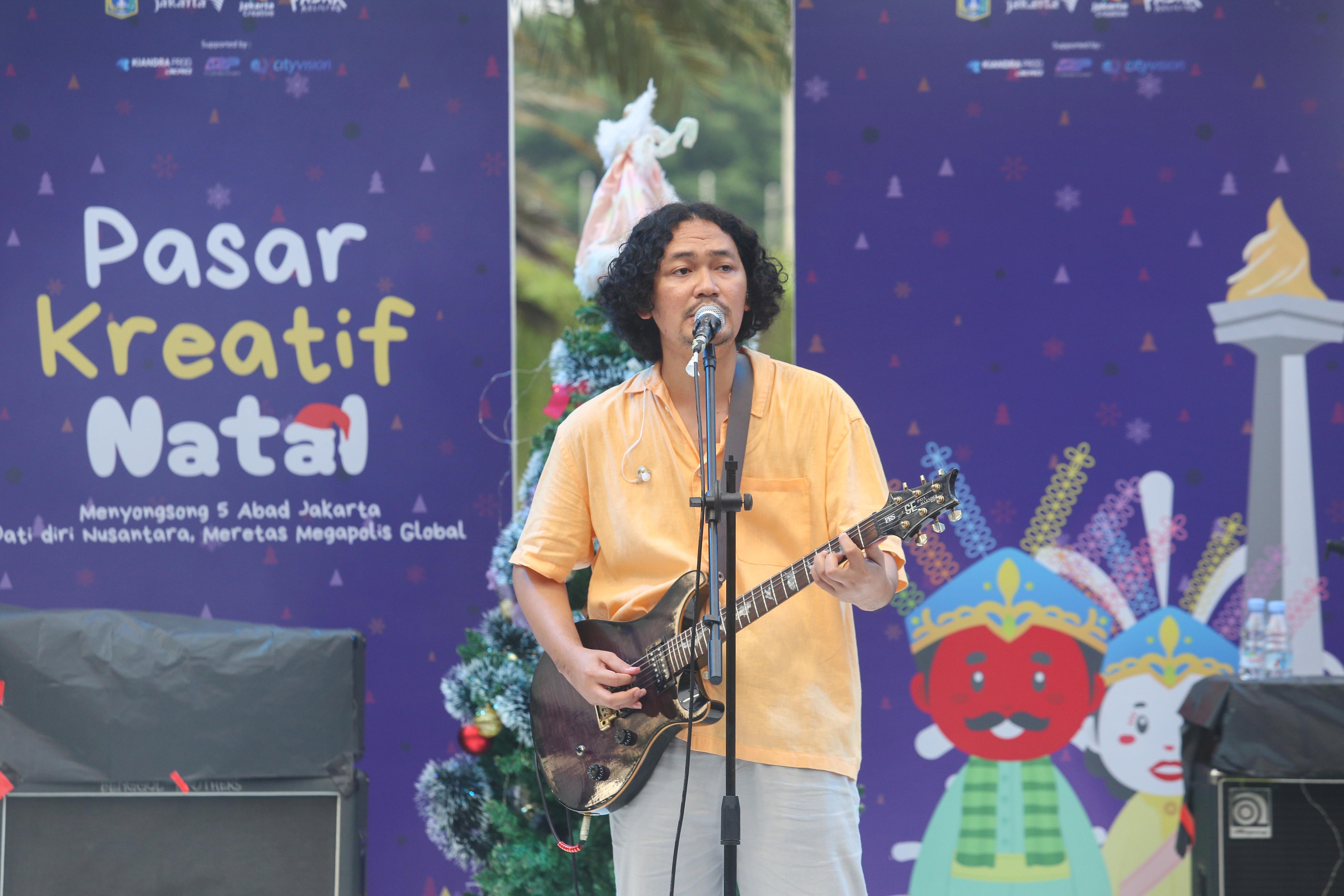 Penyanyi Krisna Trias membawakan lagu hitsnya saat tampil pada Pasar Kreatif Natal di Lapangan Banteng, Jakarta, Senin (23/12/2024). Kegiatan yang digelar dalam rangka menyambut Hari Raya Natal 2024 tersebut menghadirkan berbagai acara menarik mulai dari 70 stan UMKM makanan ringan dan produk kerajinan tangan, paduan suara kidung natal hingga penampilan musik dari Krisna Trias dan Moscato Band. 