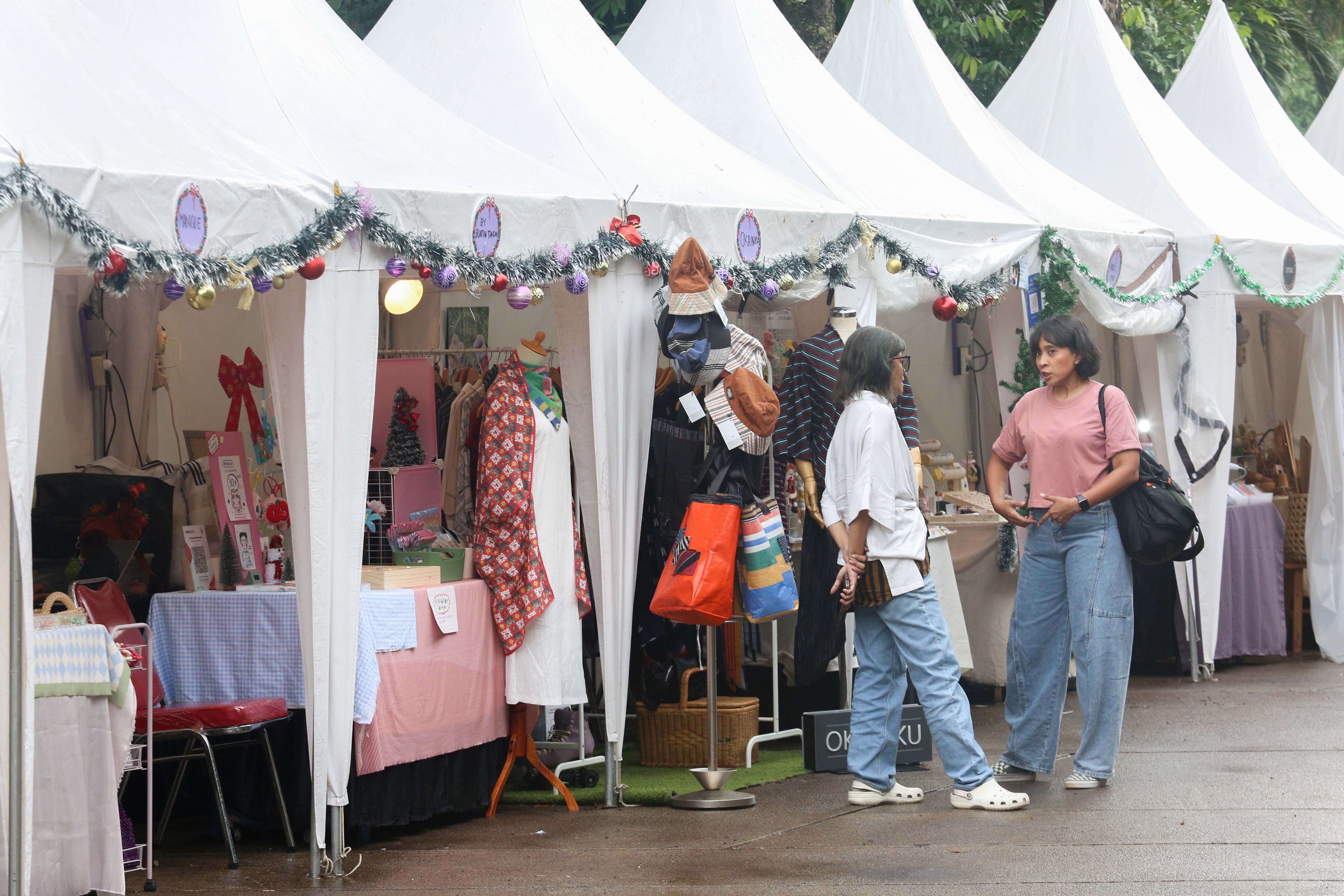 Pengunjung melihat produk UMKM yang dijual pada Pasar Kreatif Natal di Lapangan Banteng, Jakarta, Senin (23/12/2024). Kegiatan yang digelar dalam rangka menyambut Hari Raya Natal 2024 tersebut menghadirkan berbagai acara menarik mulai dari 70 stan UMKM makanan ringan dan produk kerajinan tangan, paduan suara kidung natal hingga penampilan musik dari Krisna Trias dan Moscato Band. 