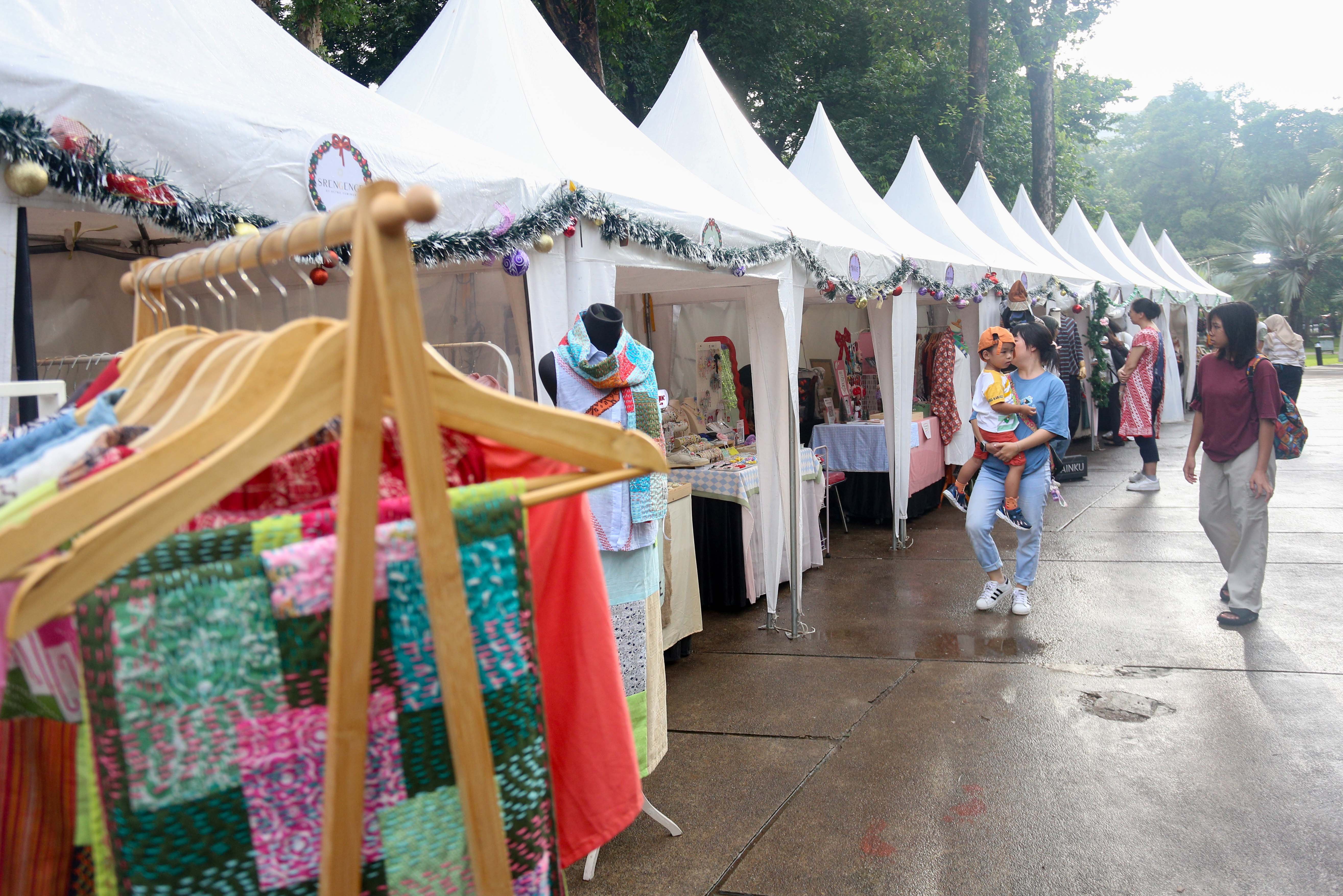 Pengunjung melihat produk UMKM yang dijual pada Pasar Kreatif Natal di Lapangan Banteng, Jakarta, Senin (23/12/2024). Kegiatan yang digelar dalam rangka menyambut Hari Raya Natal 2024 tersebut menghadirkan berbagai acara menarik mulai dari 70 stan UMKM makanan ringan dan produk kerajinan tangan, paduan suara kidung natal hingga penampilan musik dari Krisna Trias dan Moscato Band. 