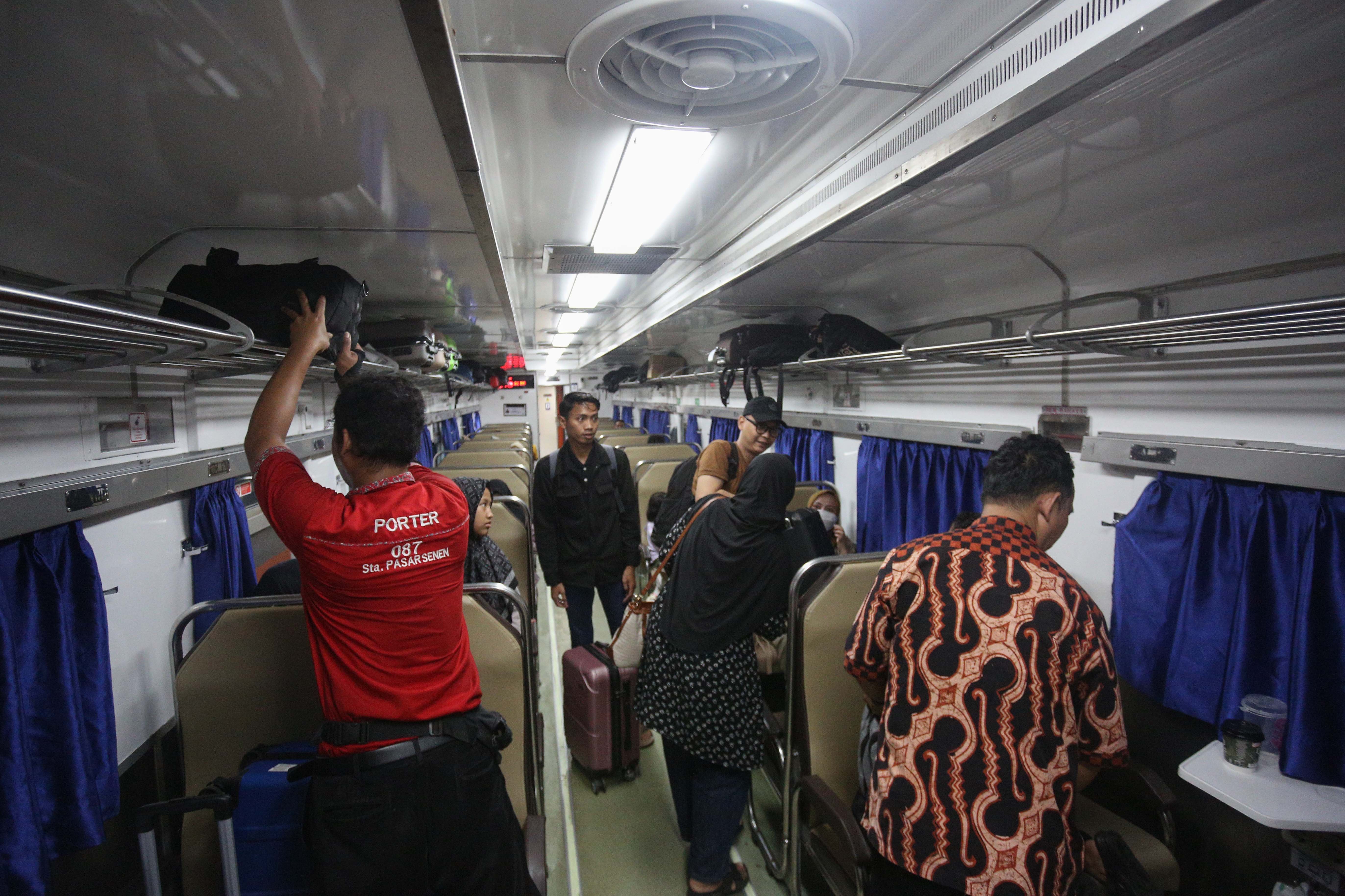 Sejumlah penumpang merapikan barang bawaannya saat berada di dalam gerbong kereta api di Stasiun Pasar Senen, Jakarta, Selasa (24/12/2024). Pada H-1 menjelang Hari Raya Natal 2024 dan H-7 Tahun Baru 2025, PT Kereta Api Indonesia (Persero) Daop 1 Jakarta memberangkatkan rata-rata 38 perjalanan kereta api jarak jauh melalui Stasiun Pasar Senen dengan jumlah penumpang sebanyak 25.357.
