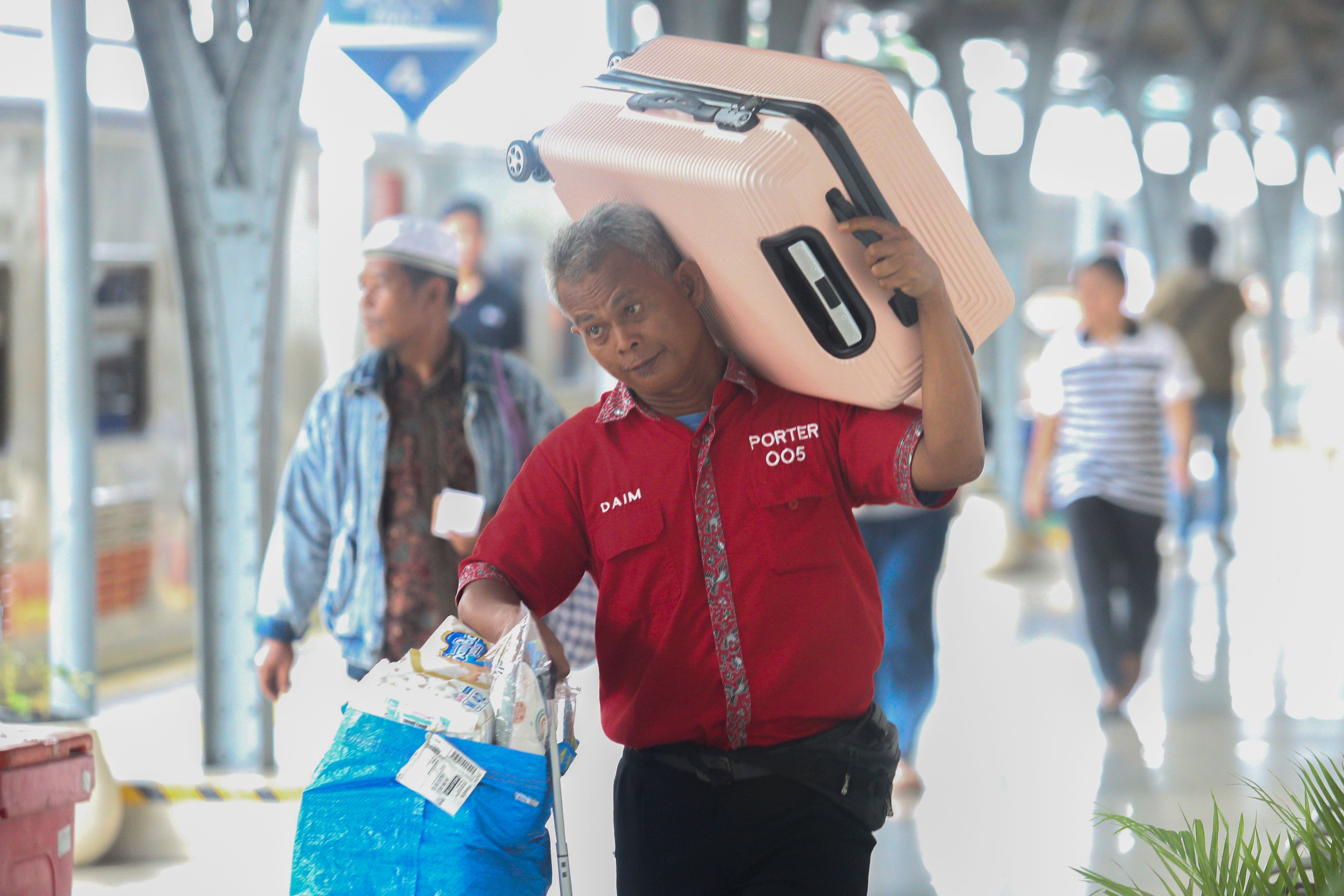 Porter membawa barang penumpang menuju gerbong kereta api di Stasiun Pasar Senen, Jakarta, Selasa (24/12/2024). Pada H-1 menjelang Hari Raya Natal 2024 dan H-7 Tahun Baru 2025, PT Kereta Api Indonesia (Persero) Daop 1 Jakarta memberangkatkan rata-rata 38 perjalanan kereta api jarak jauh melalui Stasiun Pasar Senen dengan jumlah penumpang sebanyak 25.357. 