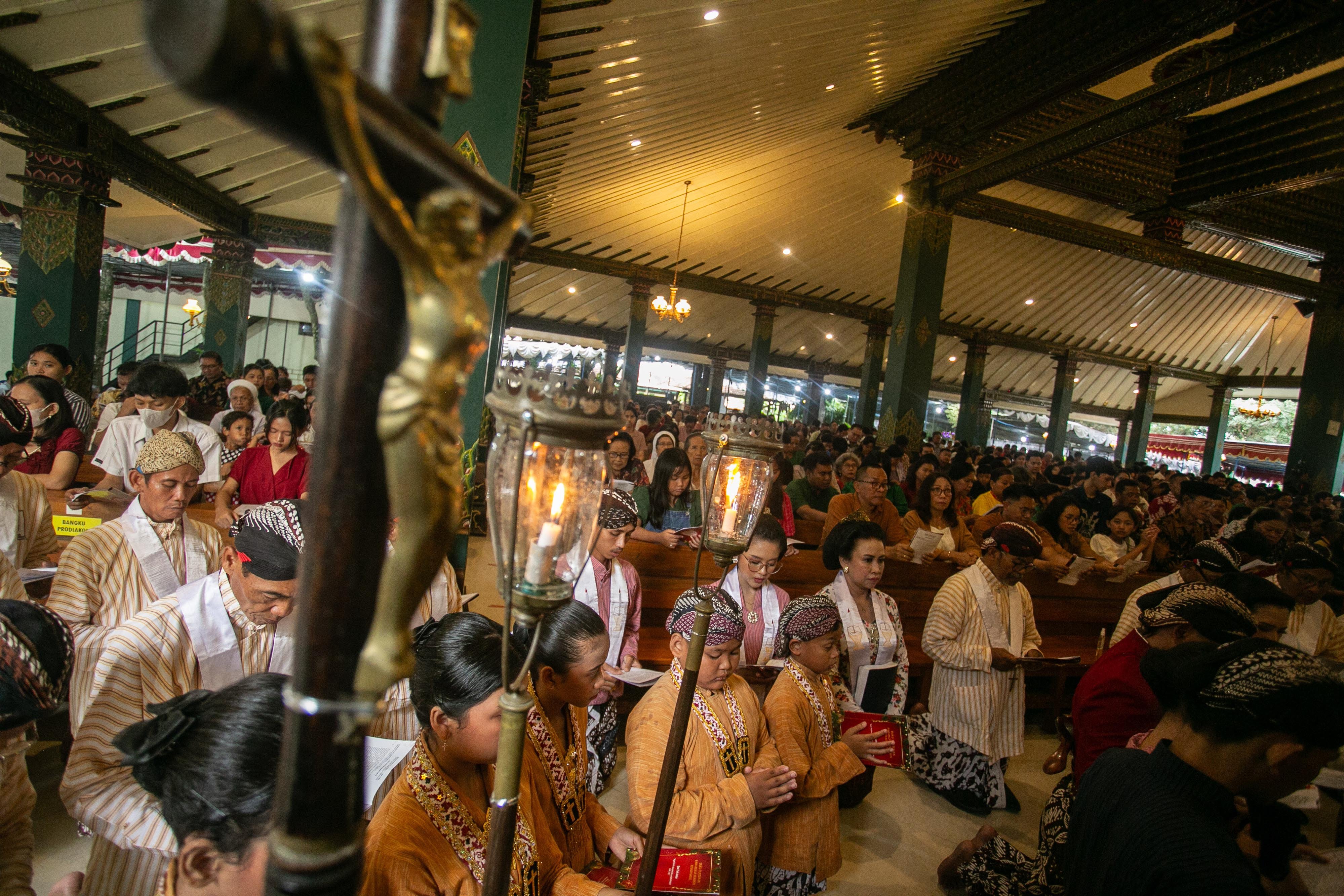 Umat Katolik mengenakan pakaian adat Jawa saat mengikuti prosesi Misa Natal di Gereja Hati Kudus Tuhan Yesus (HKTY) Ganjuran, Bantul, DI Yogyakarta, Selasa (24/12/2024). Misa Natal di gereja tersebut digelar menggunakan budaya Jawa dan iringan gamelan. 