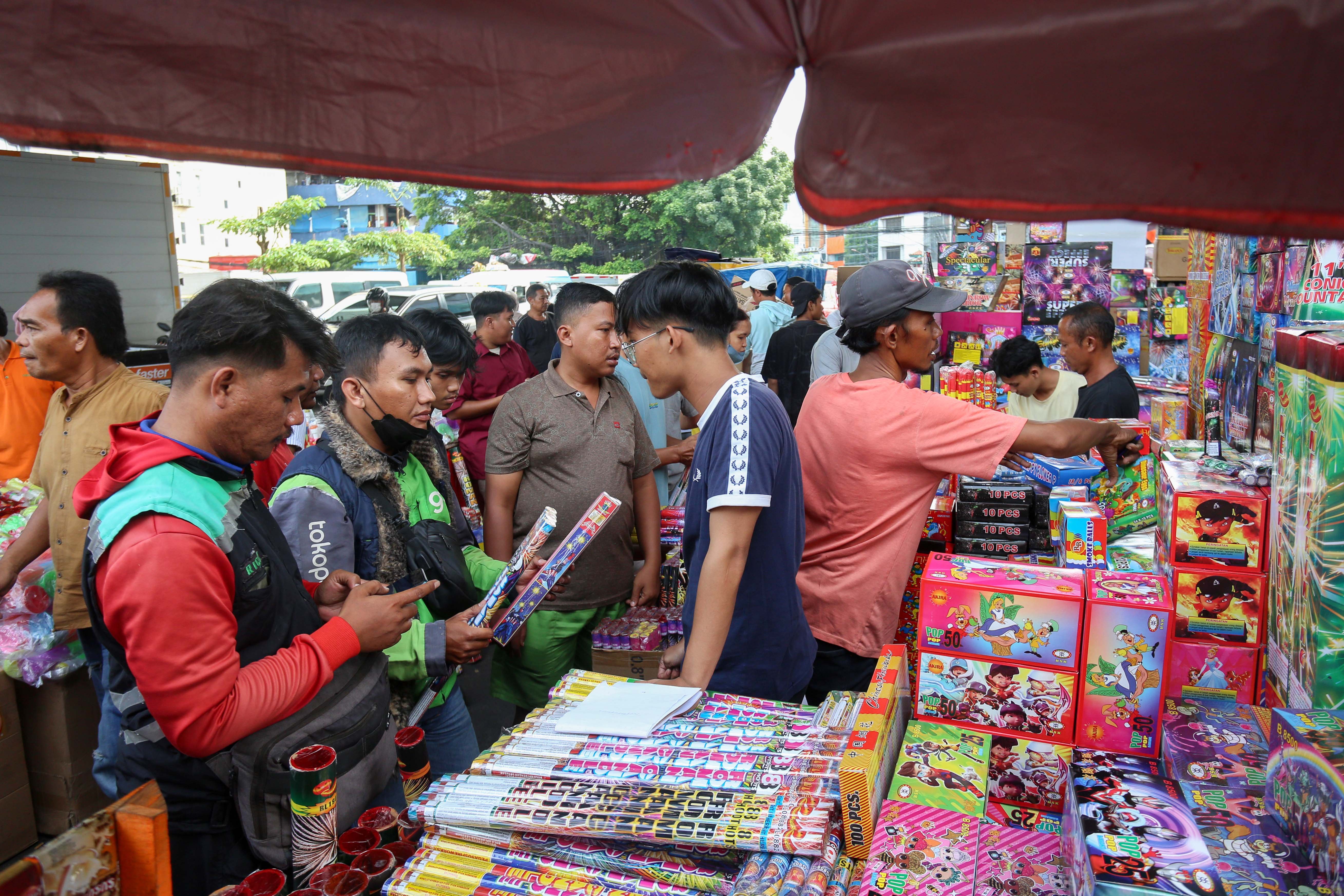 Pedagang melayani pembeli kembang api di Pasar Asemka, Jakarta, Senin (30/12/2024). Berdasarkan penuturan pedagang menjelang tahun baru 2025, penjualan kembang di pasar yang telah berdiri sejak tahun 1960-an ini mengalami kenaikan dua kali lipat dengan harga jual mulai dari Rp.10.000 hingga Rp.1 juta tergantung jenis dan ukurannya. 
