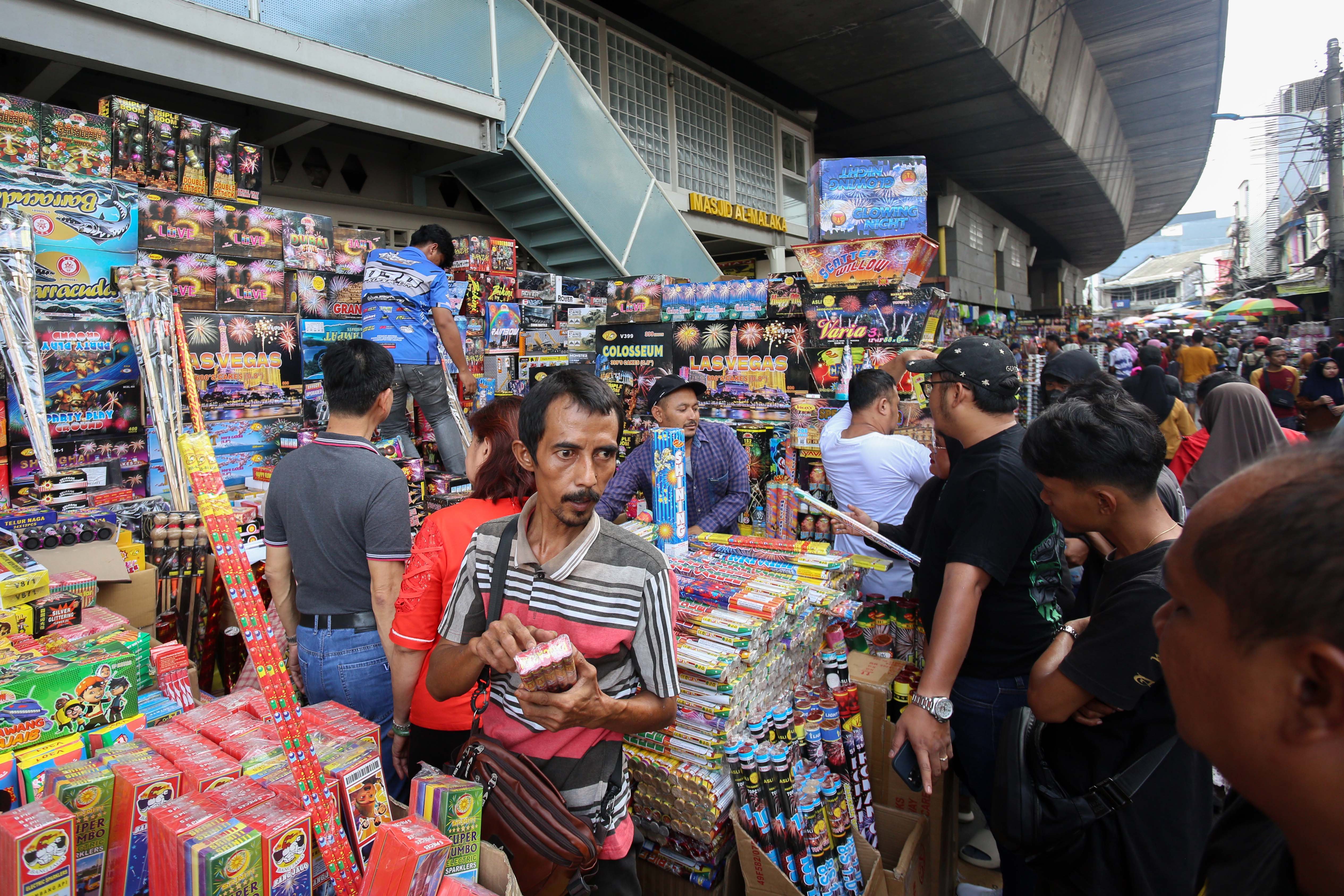 Pedagang melayani pembeli kembang api di Pasar Asemka, Jakarta, Senin (30/12/2024). Berdasarkan penuturan pedagang menjelang tahun baru 2025, penjualan kembang di pasar yang telah berdiri sejak tahun 1960-an ini mengalami kenaikan dua kali lipat dengan harga jual mulai dari Rp.10.000 hingga Rp.1 juta tergantung jenis dan ukurannya. 